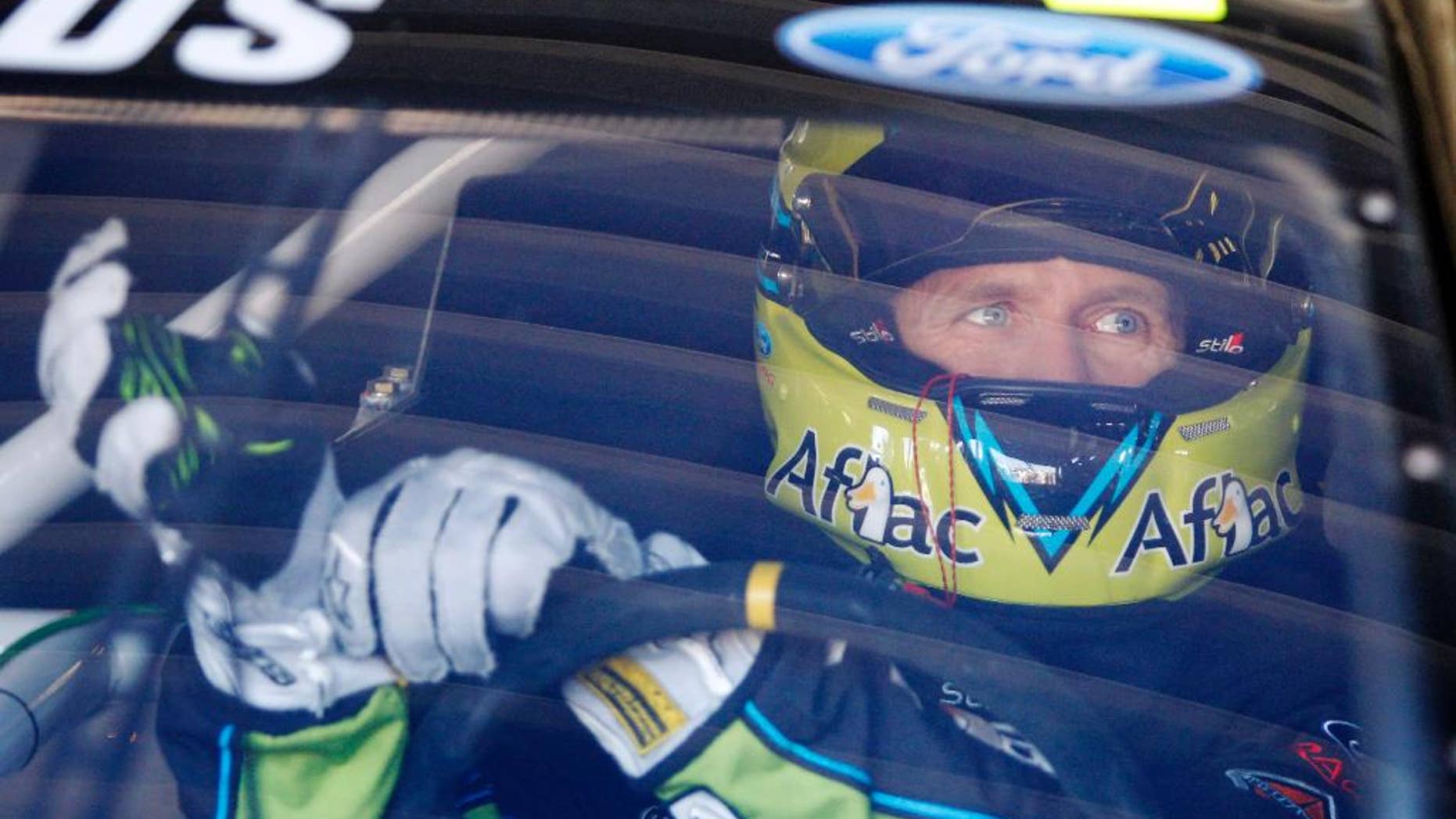Driver Carl Edwards adjusts his gloves before practice, Friday, May 9, 2014, at Kansas Speedway in Kansas City, Kan., for Saturday night's NASCAR Sprint Cup series auto race. (AP Photo/Colin E. Braley)