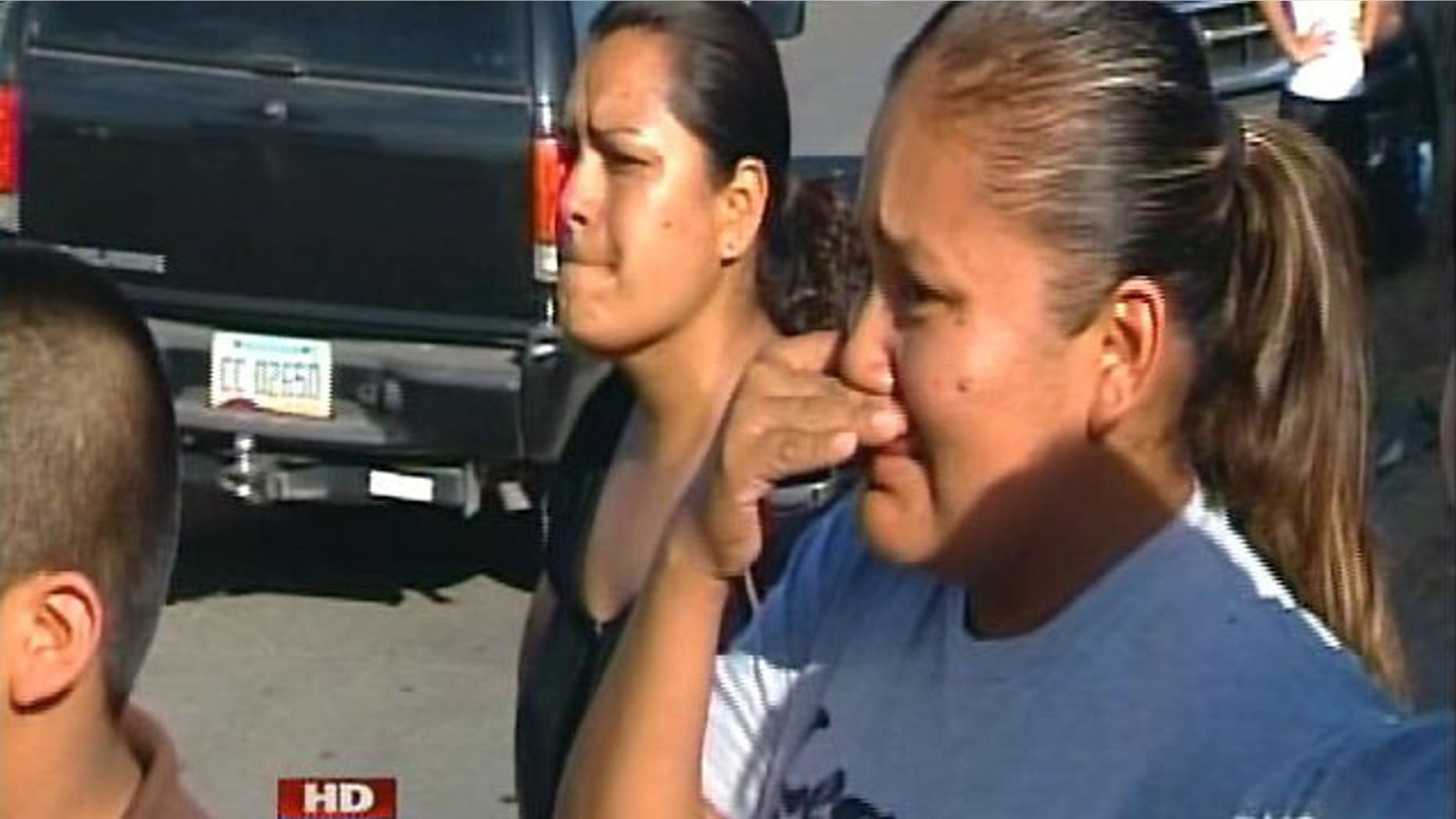 June 25: People look on as authorities raid an Arizona business as part of an identity theft investigation.