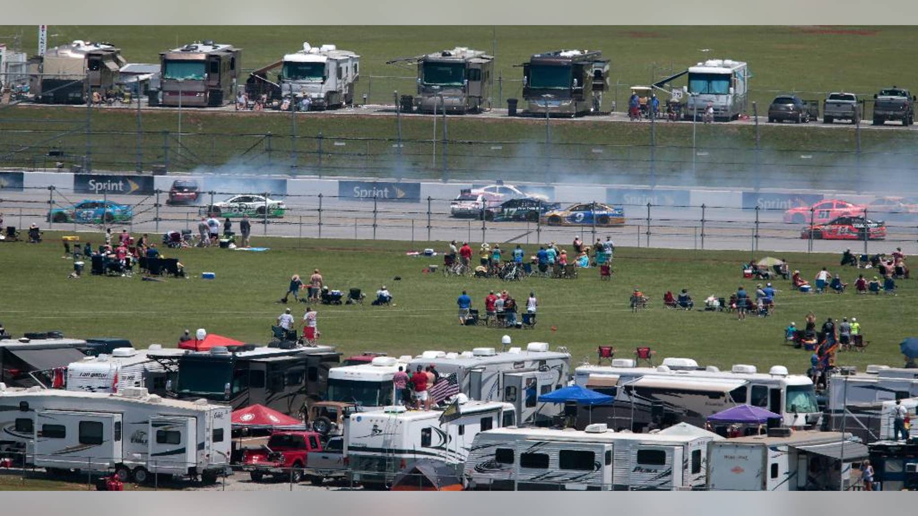 Fans watch a multi-car crash on the back straight during the Talladega 500 NASCAR Sprint Cup Series auto race at Talladega Superspeedway, Sunday, May 3, 2015, in Talladega, Ala. (AP Photo/Butch Dill)
