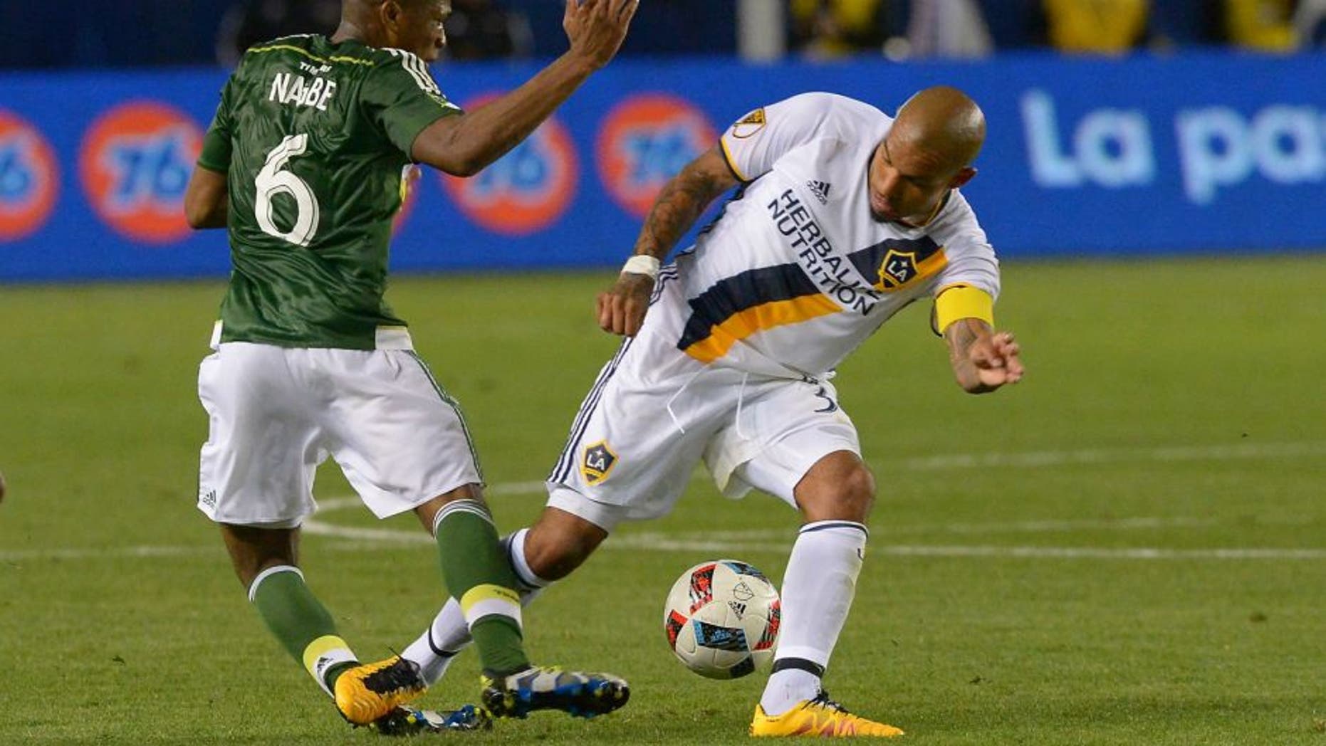 Apr 10, 2016; Carson, CA, USA; Los Angeles Galaxy midfielder Nigel de Jong (34) was given a yellow card for this collision with Portland Timbers midfielder Darlington Nagbe (6) in the second half of the game at StubHub Center. Portland Timbers midfielder Darlington Nagbe (6) left the game on a stretcher. Mandatory Credit: Jayne Kamin-Oncea-USA TODAY Sports