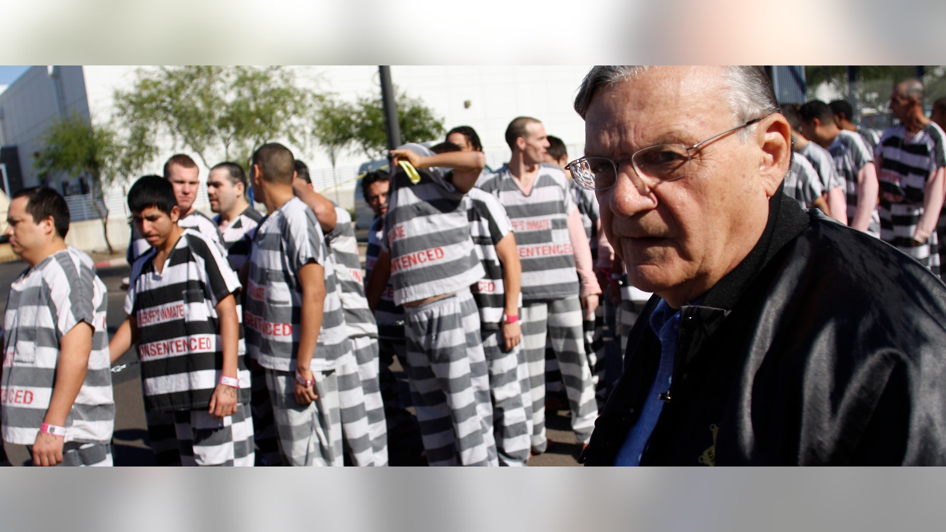 PHOENIX, AZ - APRIL 17: Inmates walk as they are moved after being ordered by Maricopa County Sheriff Officer Joe Arpaio (R), looking on, to be placed into new housing to open up new beds for maximum security inmates on April 17, 2009 in Phoenix, Arizona. Arpaio has been facing criticism from Hispanic activists and lawmakers, alleging that Arpaio's crackdown methods on illegal immigrants involve racial profiling. (Photo by Joshua Lott/Getty Images) *** Local Caption *** Joe Arpaio