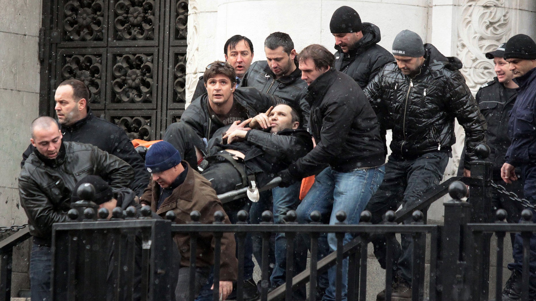 Bodyguards carry Zlatomir Ivanov, after he was shot in front of central court house in downtown Sofia, Tuesday, Jan. 29, 2013. Unidentified gunmen have shot and seriously wounded Zlatomir Ivanov who is alleged to be an underworld boss. Convicted underworld boss, Zlatomir Ivanov was on his way to the Sofia Court House on Tuesday when the shooter opened fire, probably from an opposite building, a senior police officer said. Ivanov and one of his bodyguards were both hit as they walked up the stairs to enter the court. Police say Ivanov was undergoing surgery after suffering four gunshots. (AP Photo)