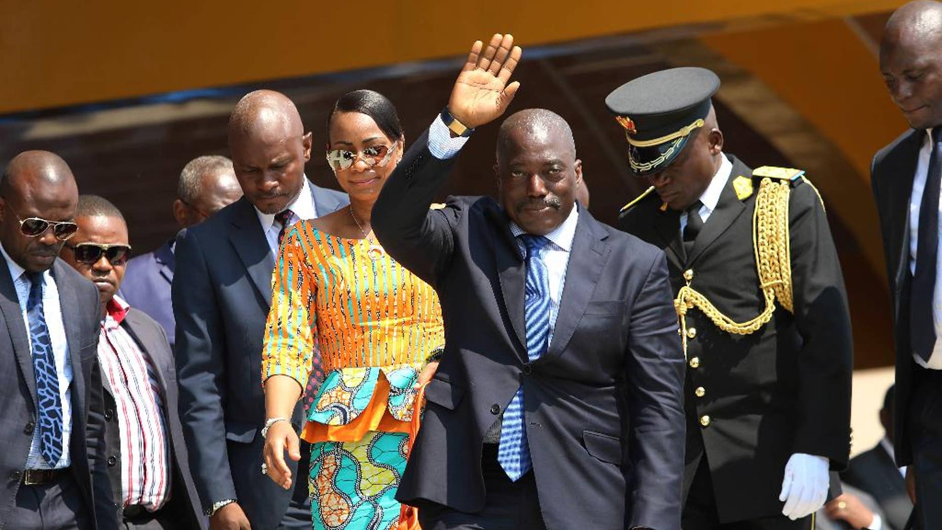 FILE- In this Thursday, June 30, 2016 file photo, Congolese President Joseph Kabila, center, waves as he and others celebrate the Democratic Republic of Congo, DRC, independence in Kindu, Congo. Congo's ruling party is proposing an interim unity government with the opposition as an election set for November, 2016, now seems nearly impossible, though President Joseph Kabila would remain in charge, the country's justice minister said. (AP Photo/John Bompengo, File)