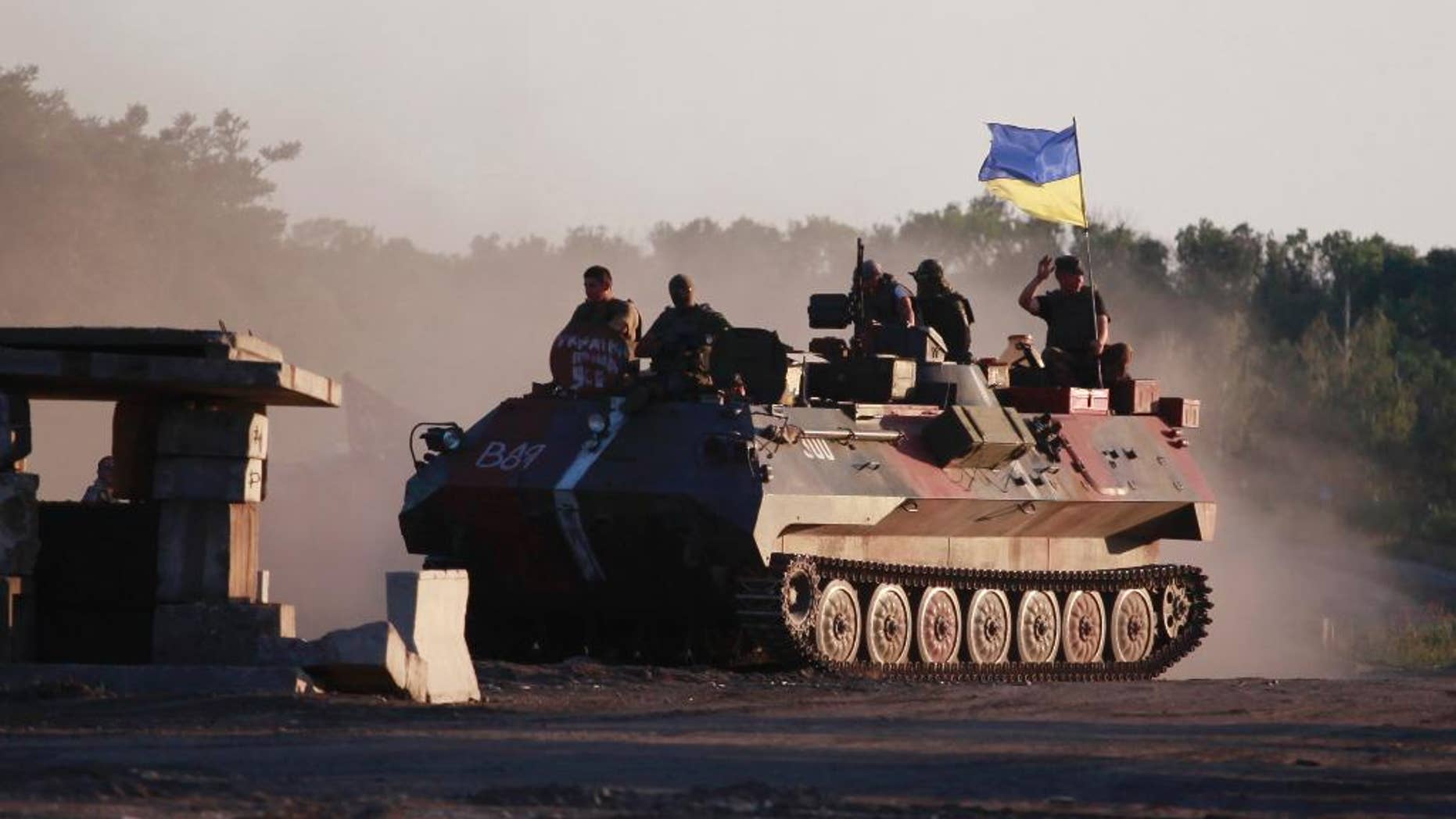 FILE - In this Aug 20, 2014 file photo file photo Ukrainian soldiers muster at a point close to Luhansk, eastern Ukraine. The leading Western democracies used the G-7 summit in Schloss Elmau hotel to present a united front on the actions in Ukraine of Russia, which they ejected from what used to be the G-8 last year following its annexation of the Crimean peninsula. They made clear that any lifting of sanctions depends on Russia fully implementing a peace accord brokered in Minsk in February by Germany and France, and said they “also stand ready to take further restrictive measures in order to increase cost on Russia should its actions so require.” (AP Photo/Petro Zadorozhnyy)