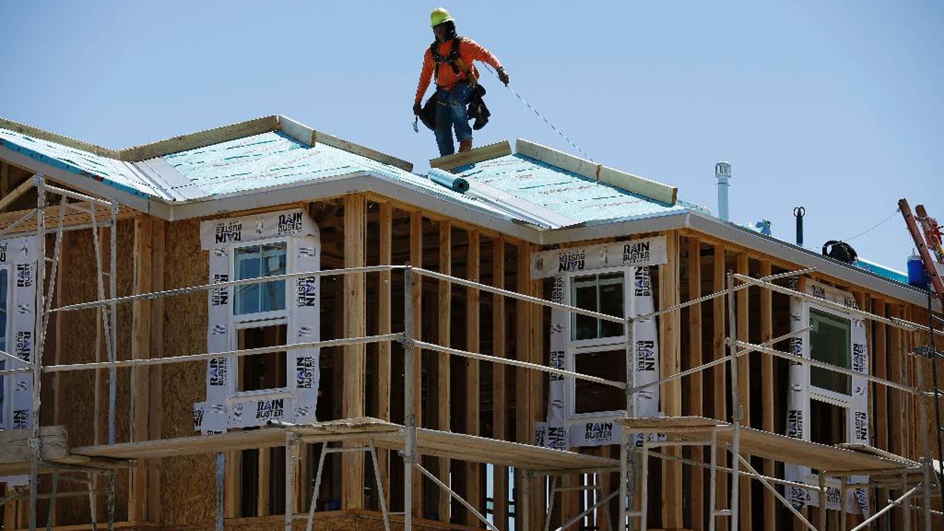 In this April 13, 2015, photo, a worker helps to build a new home in Las Vegas. The Conference Board releases its index of leading indicators for April on Thursday, May 21, 2015. (AP Photo/John Locher)