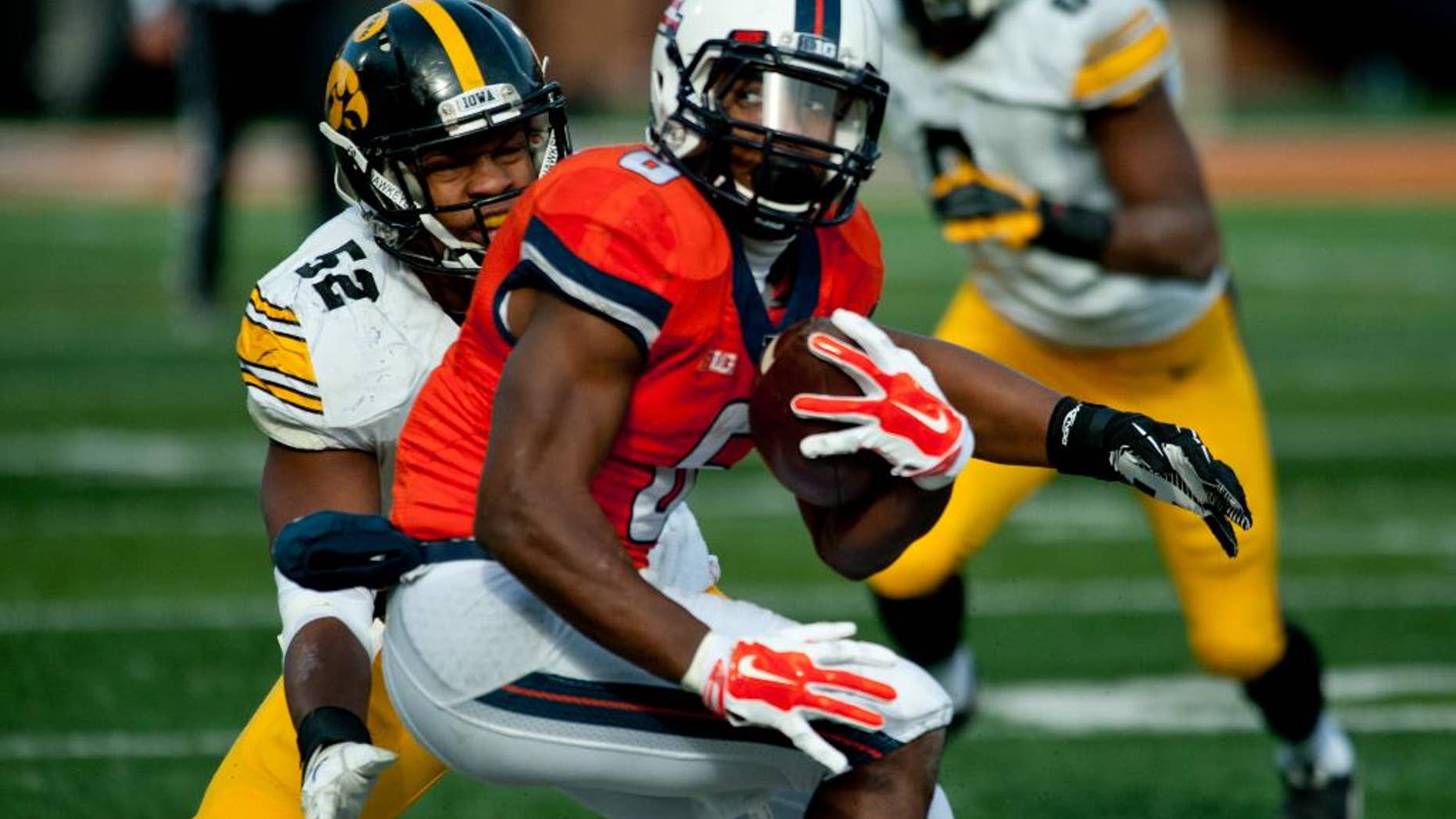 Illinois running back Josh Ferguson (6) tries to avoid a tackle by Iowa linebacker Quinton Alston (52) during the fourth quarter of an NCAA football game Saturday, Nov. 15, 2014, at Memorial Stadium in Champaign, Ill. (AP Photo/Bradley Leeb)