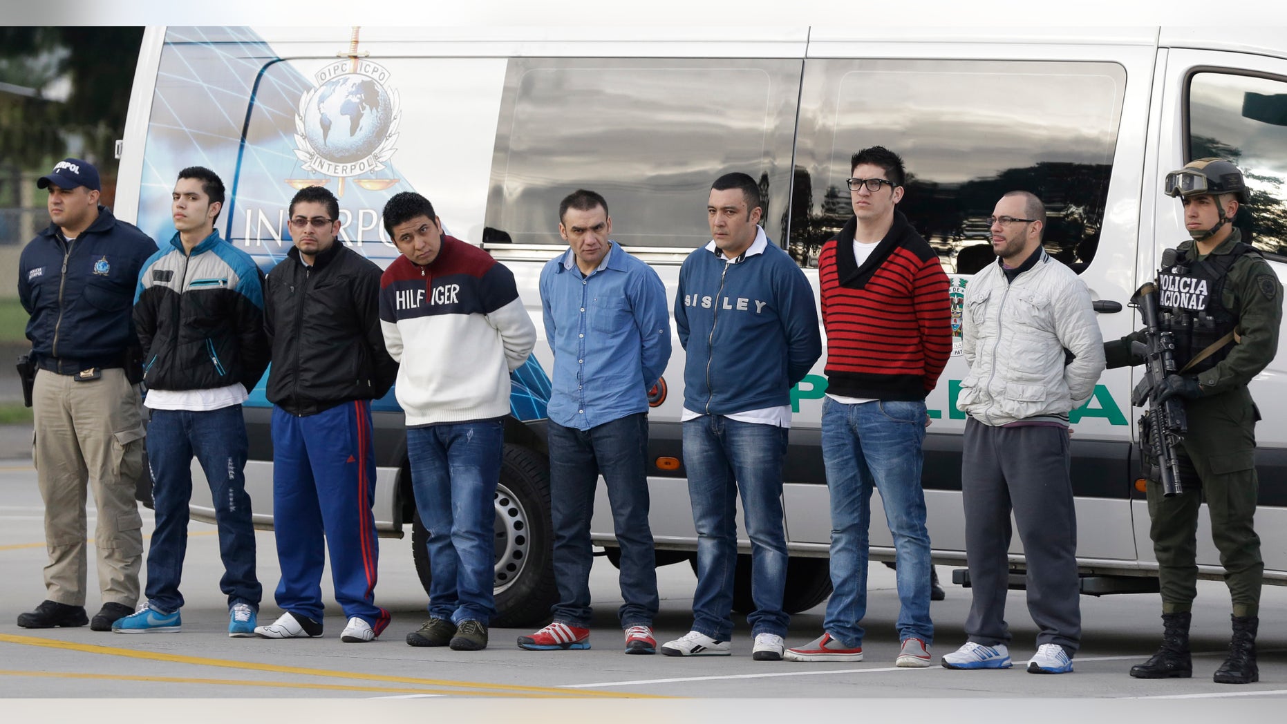 July 1, 2014: Police flank seven men accused of murdering a Drug Enforcement Administration agent, during a media presentation at the counter-narcotics base in Bogota, Colombia.
