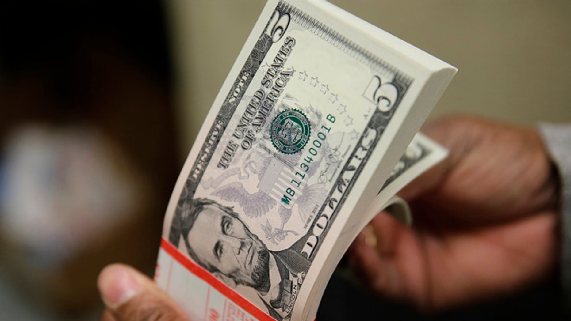 March 26, 2015: A packet of former U.S. President Abraham Lincoln five-dollar bill currency is inspected at the Bureau of Engraving and Printing in Washington.
