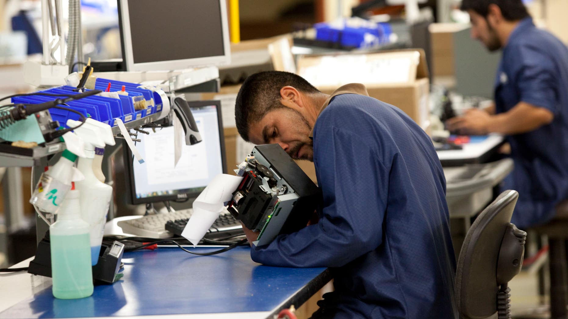 Oscar Lira of Zacatecas, Mexico repairs a receipt printer at a maquiladora belonging to the TECMA group.