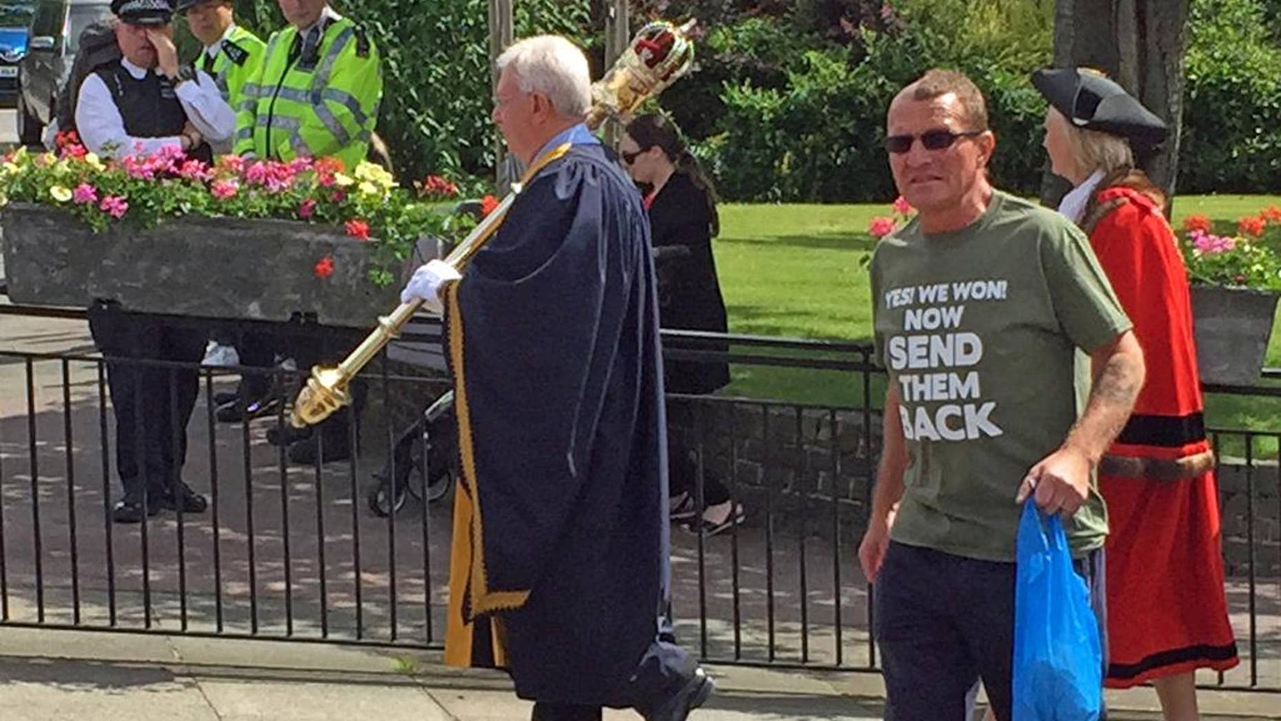 In this photo made available by Diamond Geezer, a man wearing an anti immigration T-shirt walks during Armed Forces Day Parade in Romford, England, Saturday 25 June 2016. Britain's Prime Minister David Cameron and the Mayor of London Sadiq Khan warned Monday June 27, 2016 that abuse directed at immigrants wouldn't be tolerated, after a series of incidents were reported following the country's decision to leave the European Union. ( Diamond Geezer via AP)