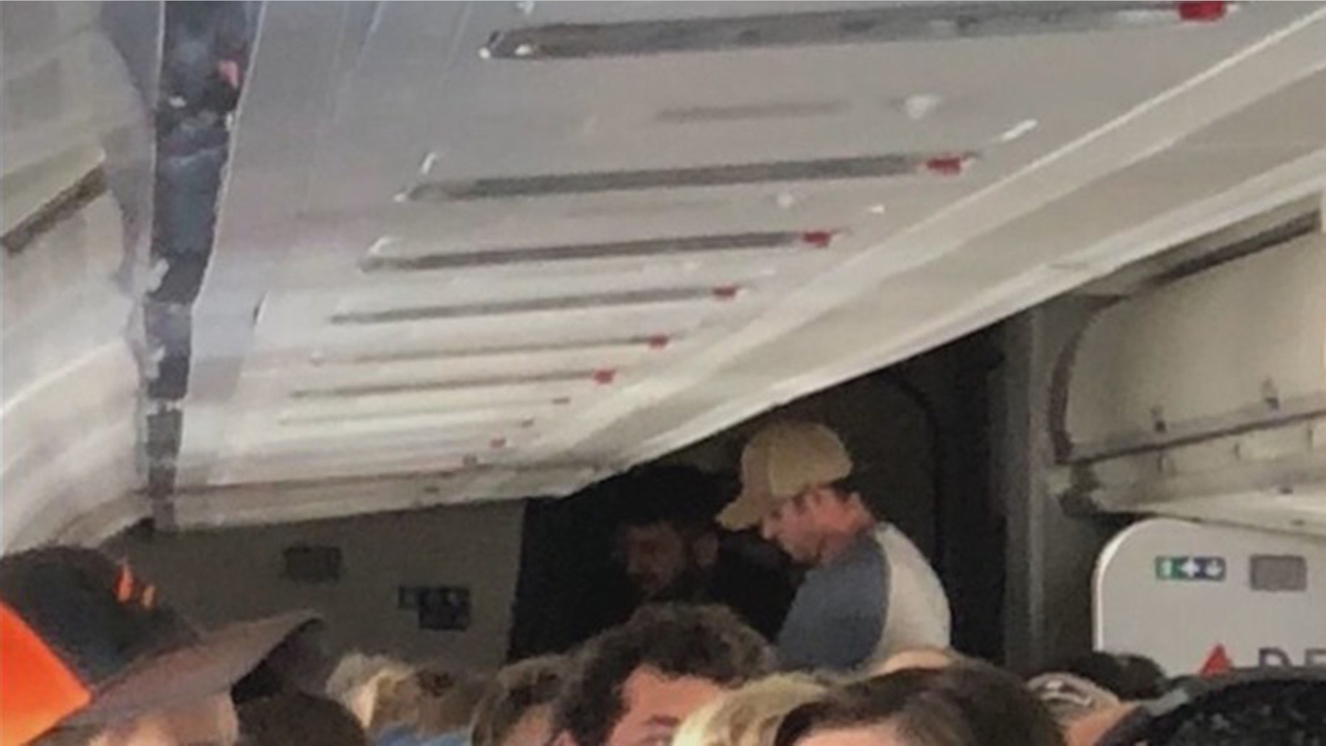 Ex-corrections officer James Tunnell (standing, wearing a tan hat) and a member of the Coast Guard sprang into action to restrain the unruly passenger.