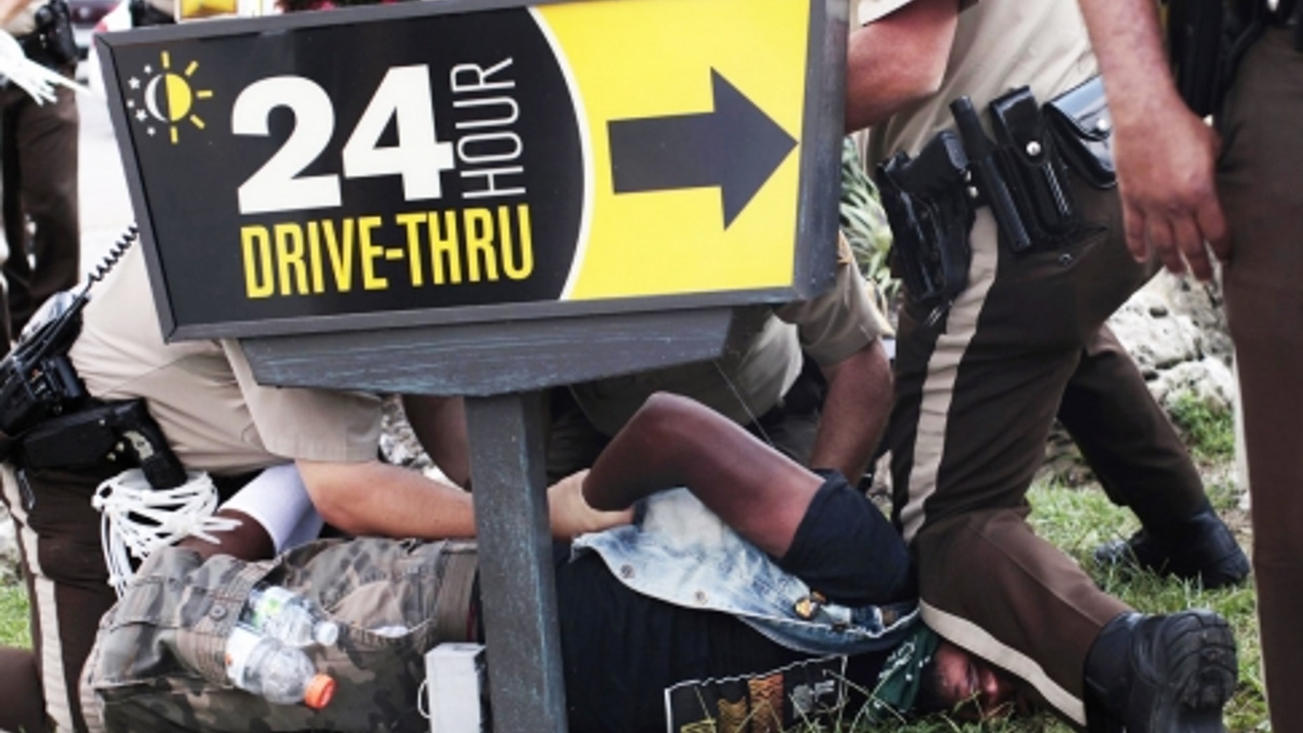 Police officers detain a demonstrator in Ferguson, Mo.