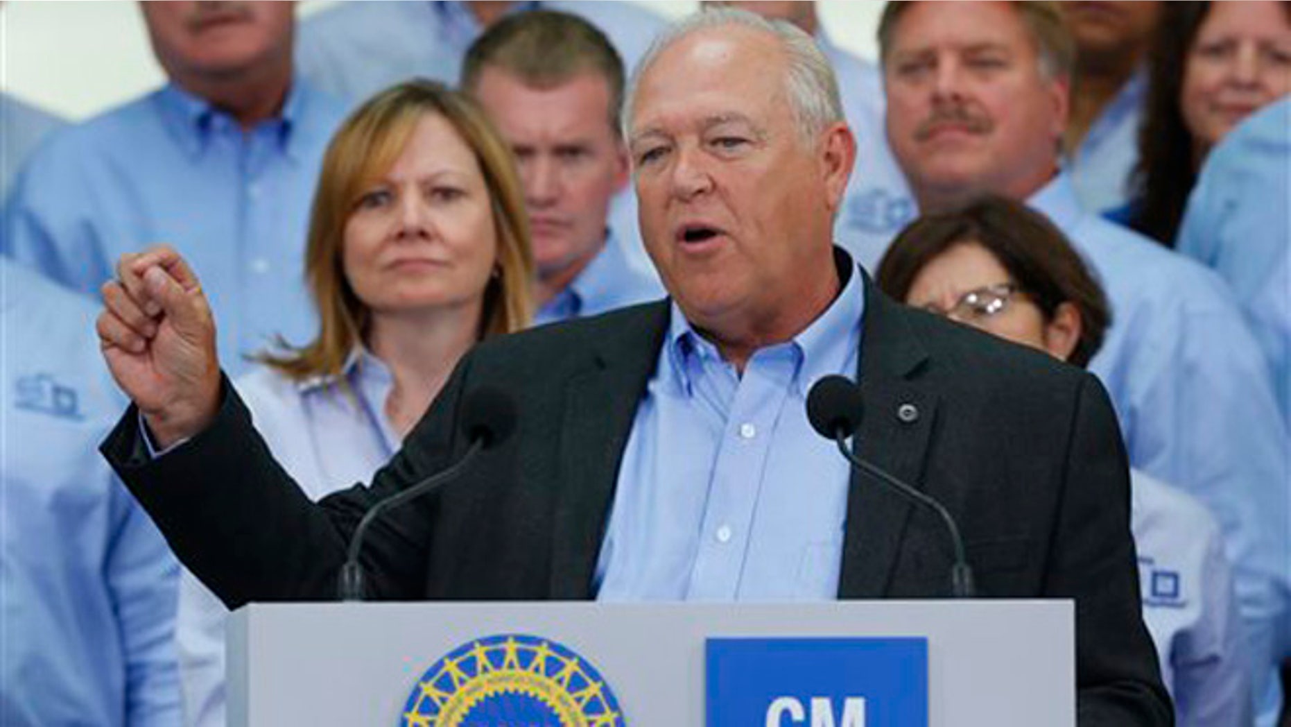 July 13, 2015: United Auto Workers President Dennis Williams speaks as General Motors CEO Mary Barra, background left, listens during a ceremony to mark the opening of contract negotiations in Detroit.
