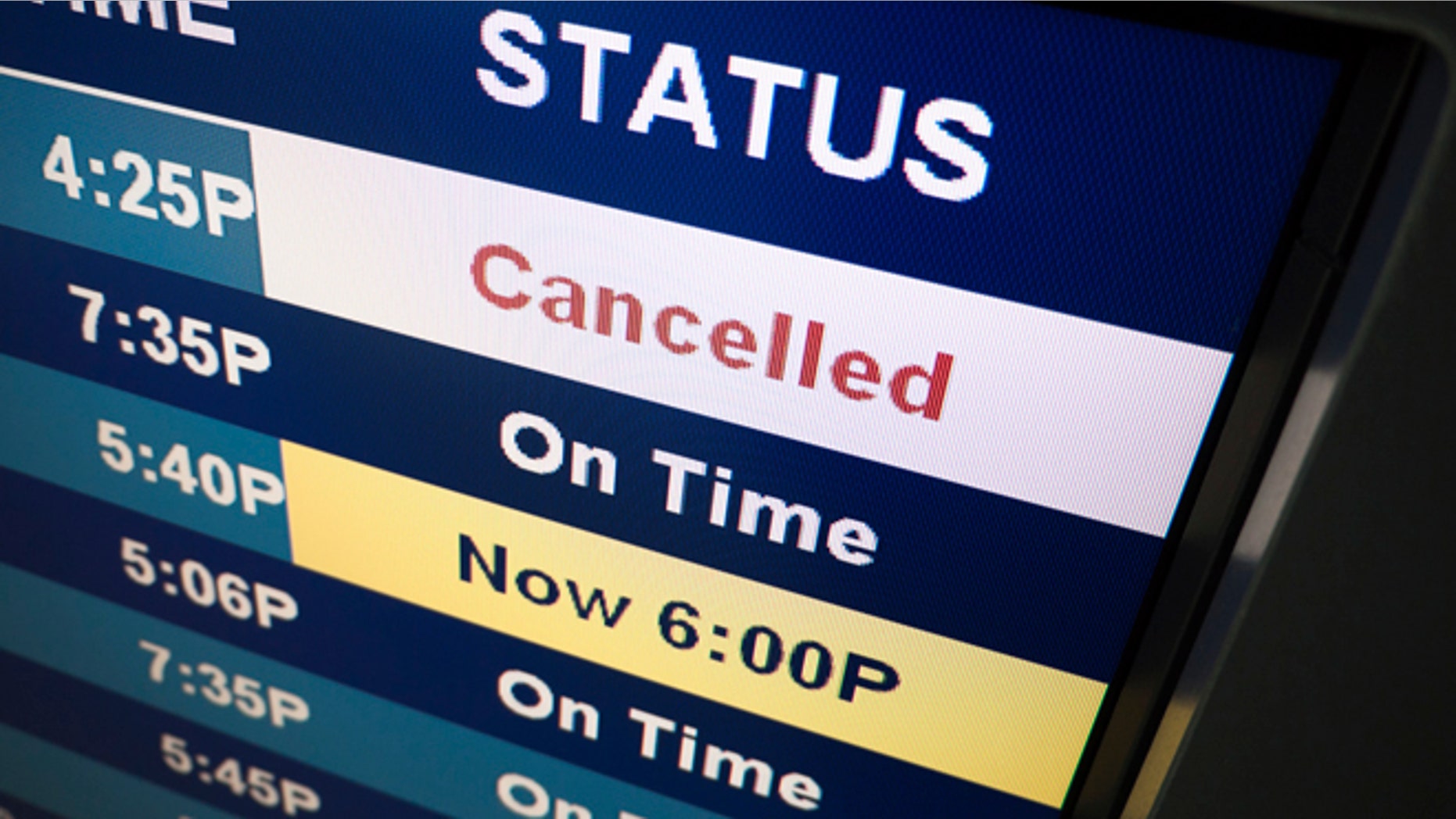 Flight cancelled notice on an airport arrival departure board sign.