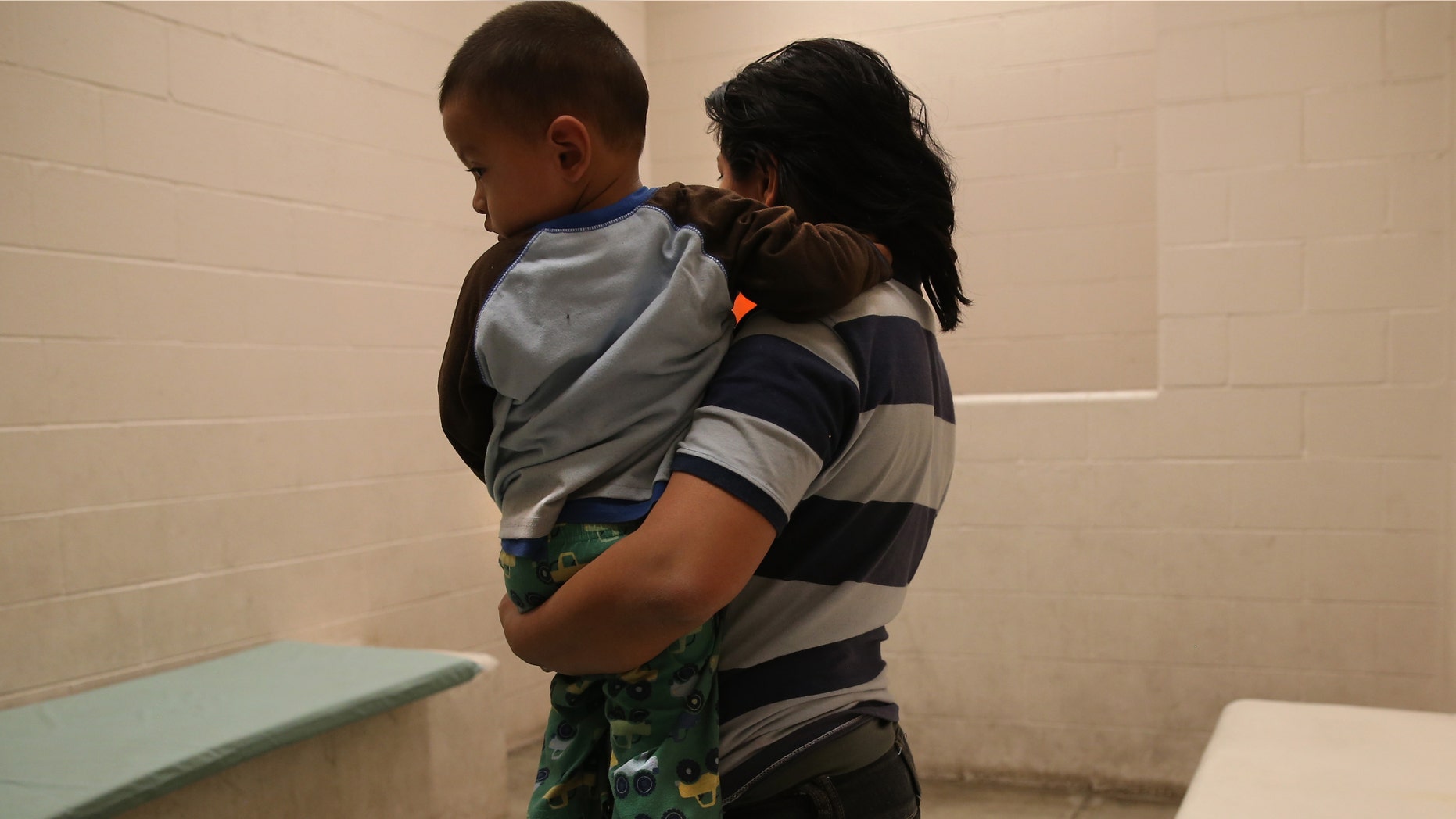 MCALLEN, TX - APRIL 11: A Honduran mother holds her toddler son at the U.S. Border Patrol detainee processing center on April 11, 2013 in McAllen, Texas. They had been caught by the Border Patrol while crossing illegally from Mexico into Texas. According to the Border Patrol, undocumented immigrant crossings have increased more than 50 percent in Texas' Rio Grande Valley sector in the last year. With more apprehensions, they have struggled to deal with overcrowding while undocumented immigrants are processed for deportation. (Photo by John Moore/Getty Images)