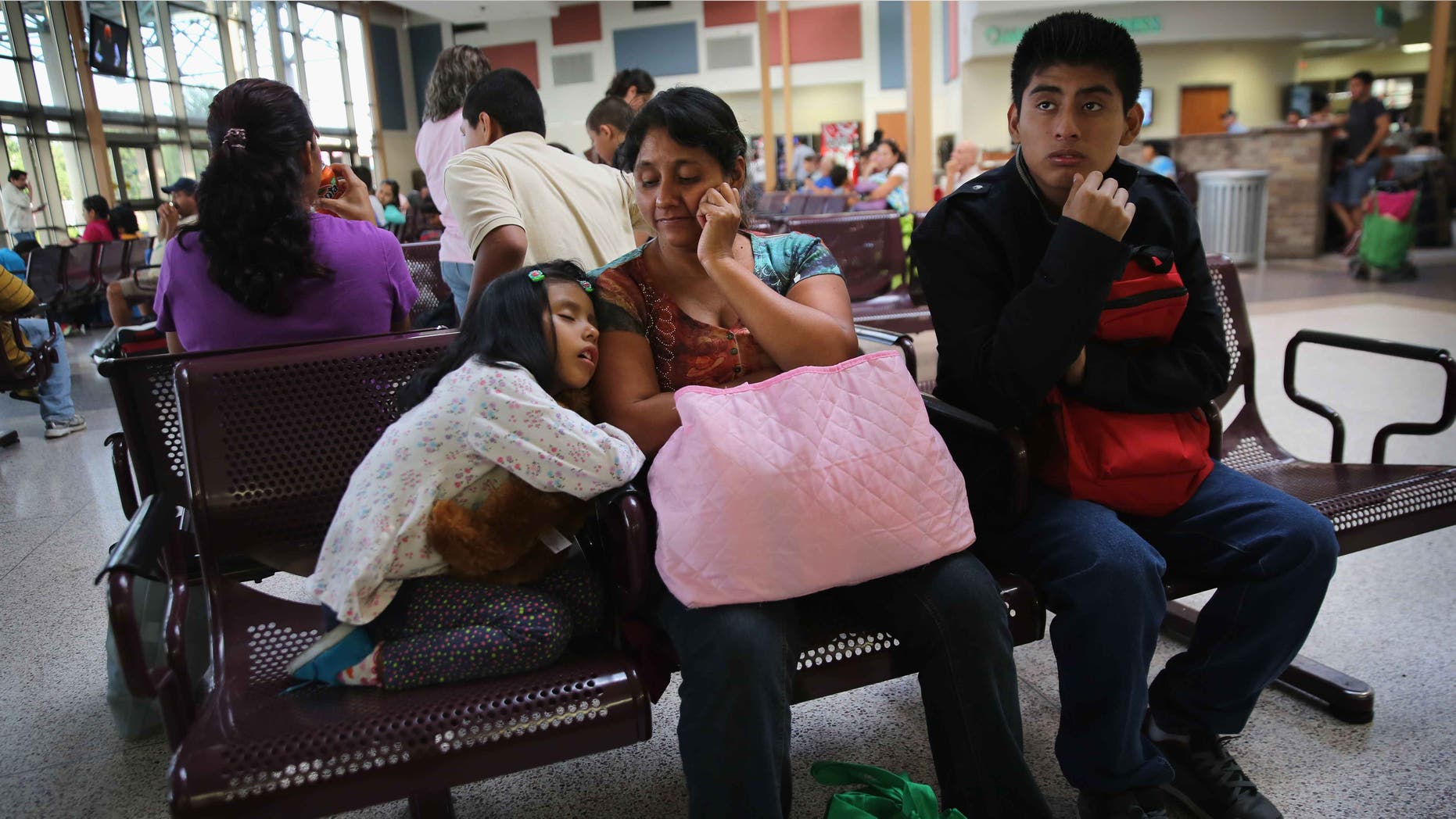 A Guatemalan family waits at the Greyhound bus station before their trip to Maryland on July 25, 2014 in McAllen, Texas.