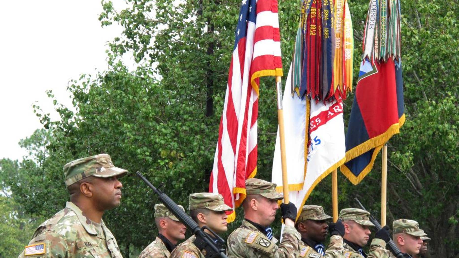 Col. Reginald Neal, far left, commander of the 48th Infantry Brigade of the Georgia National Guard, stands with an Army color guard Friday, Sept. 16, 2016 during a ceremony at Fort Stewart, Ga., to mark the brigade's new alignment with the Army's 3rd Infantry Division. The Army is pairing a dozen National Guard and Reserve units nationwide with active-duty commands, hoping to improve the combat readiness of citizen-soldiers. (AP Photo/Russ Bynum)