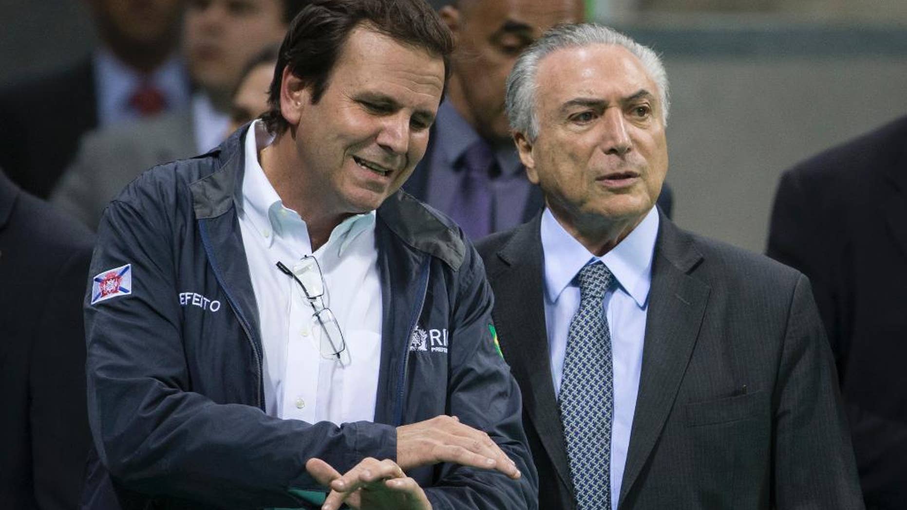 Brazil's interim President Michel Temer, right, talks to Rio de Janeiro Mayor Eduardo Paes as they visit Olympic Park in Rio de Janeiro, Brazil, Tuesday, June 14, 2016. In recent weeks Temer has stepped up his pledges of support for Rio games, which have been beset by a series of problems including the ongoing political crisis, Brazil's worst recession in decades and an outbreak of the Zika virus, which has been linked to birth defects in infants. (AP Photo/Felipe Dana)