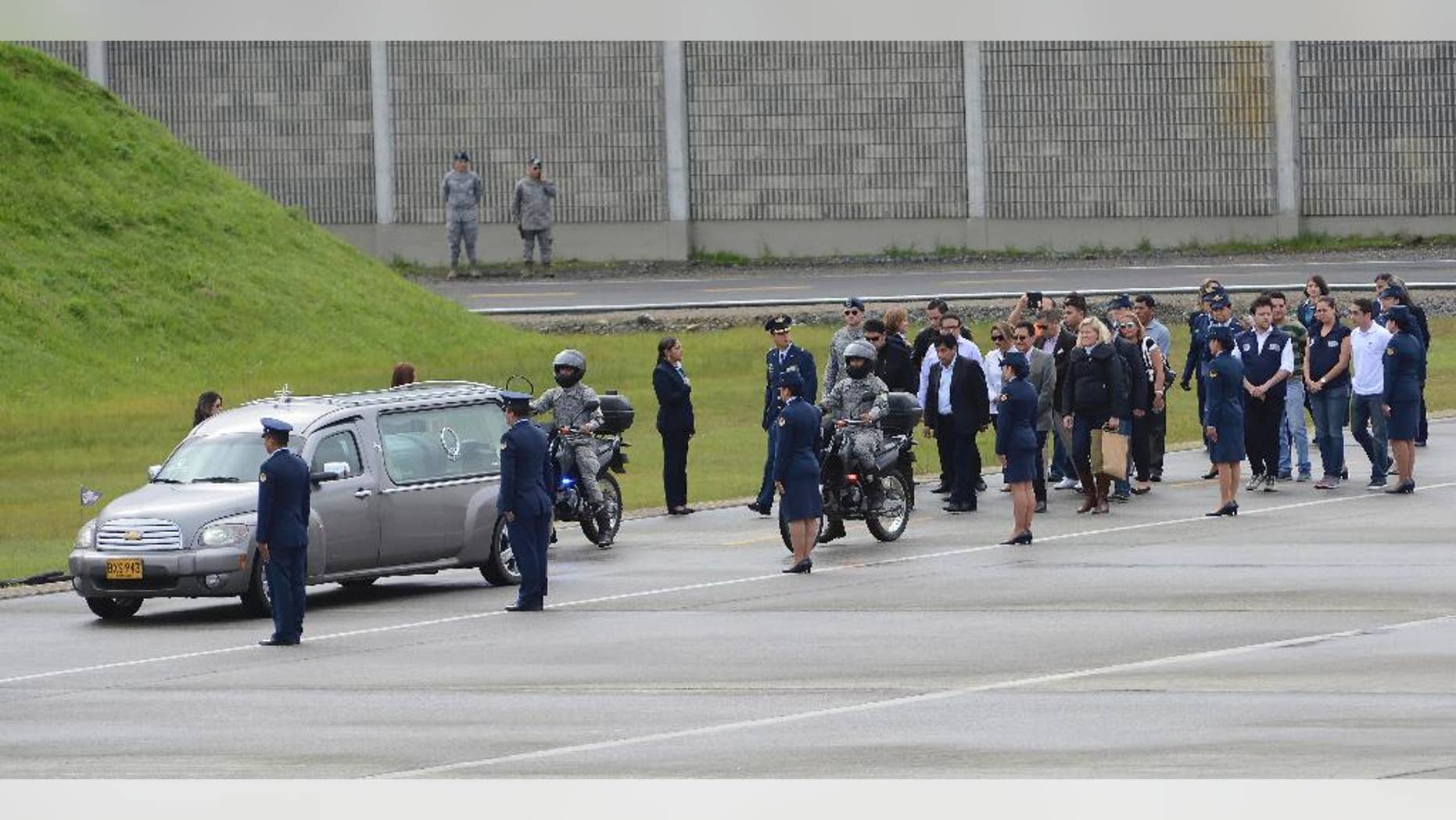 Relatives walk behind a hearse transporting a casket containing the remains of a LaMia flight crew victim to a waiting cargo plane at the military airbase in Rio Negro, Colombia, Friday, Dec. 2, 2016. An honor guard played taps early Friday as members of Colombia's military loaded the five flight crew victims of an air crash that also killed most members of a soccer team and a group of journalists, onto a cargo plane for the trip back to their native Bolivia. (AP Photo/Luis Benavides)