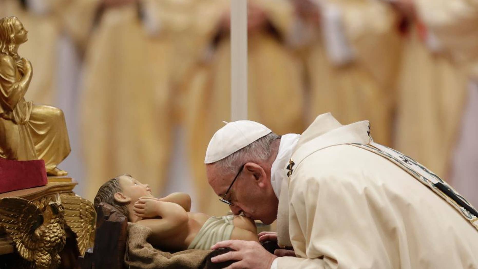 Pope Francis kisses a statue of the Divine Infant as he celebrates an Epiphany Mass in St. Peter's Basilica at the Vatican, Friday, Jan. 6, 2017. (AP Photo/Andrew Medichini)