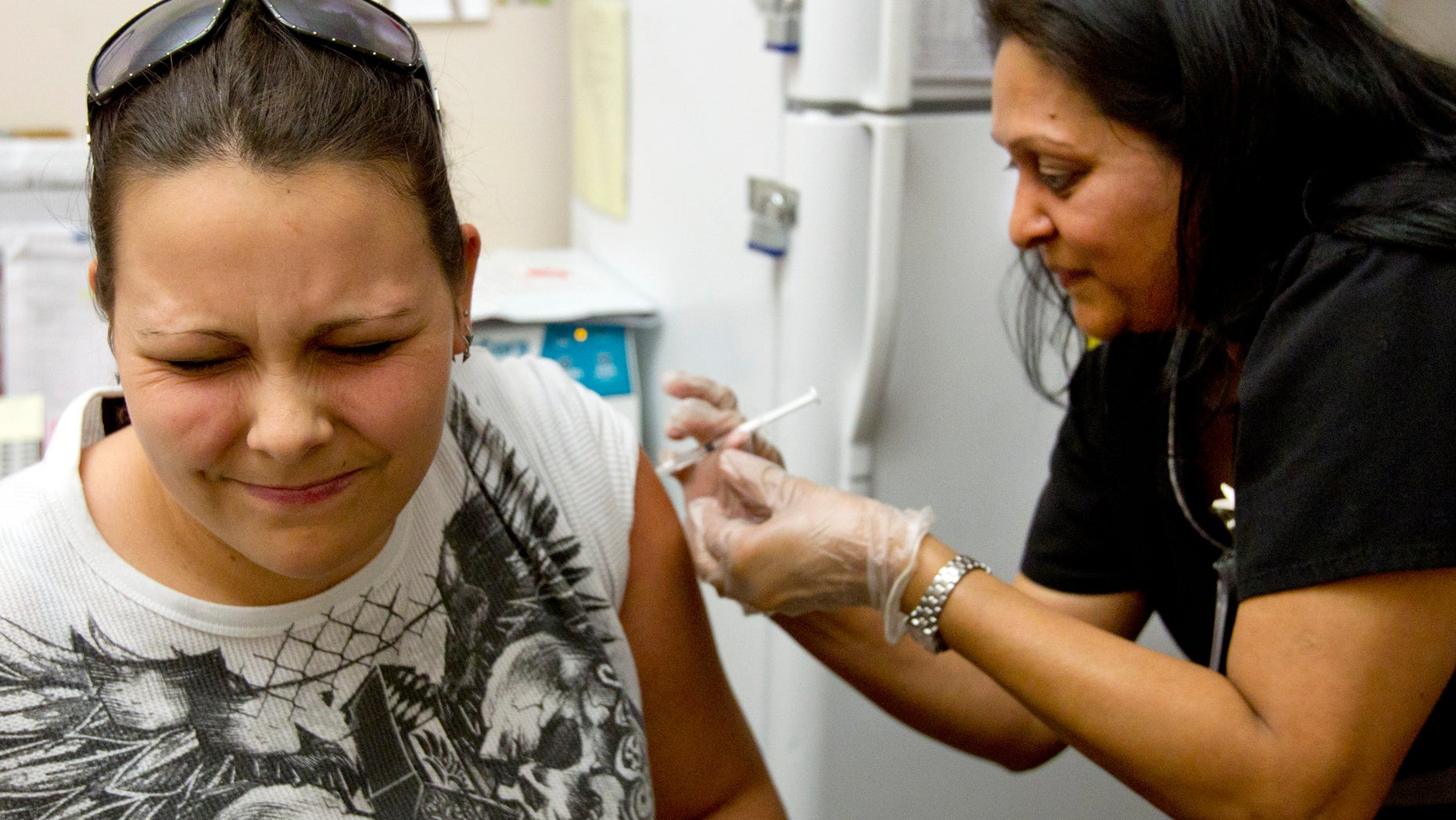 Stephanie Dugger, 20, of Apache Junction, gets a flu shot from nurse Bhagwati Bhakta at Mollen Immunization Clinics in Scottsdale, Ariz. Thursday, Jan. 10, 2013. Arizona health officials say flu activity is widespread in the state this week with influenza reported in 14 of its 15 counties. (AP Photo/The Arizona Republic, Cheryl Evans) MARICOPA COUNTY OUT; MAGS OUT; NO SALES