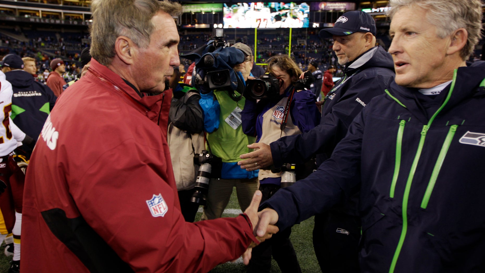 FILE - This Nov. 27, 2011 file photo shows Seattle Seahawks head coach Pete Carroll, right, greeting Washington Redskins head coach Mike Shanahan, after the Redskins won 23-17 in an NFL football game in Seattle. Once nearly co-workers, Carroll and Shanahan will meet on Sunday, Jan. 6, 2013 in the NFC playoffs when Seattle visits Washington. (AP Photo/Ted S. Warren, File)