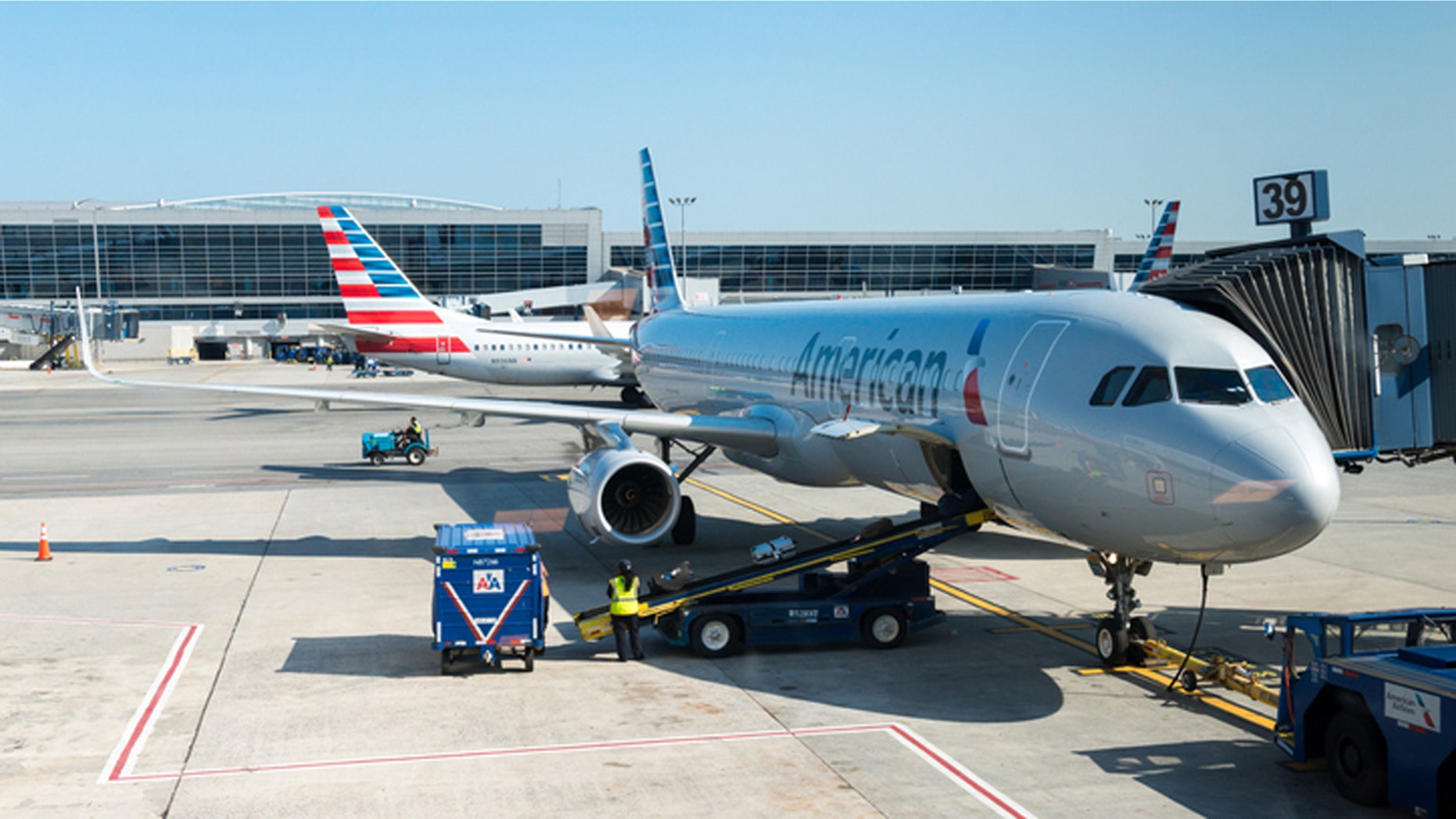 New York, USA - July 10, 2015: An America Airlines plane sitting at gate 39 at JFK airport late in the day as ground crew finish up before take off.
