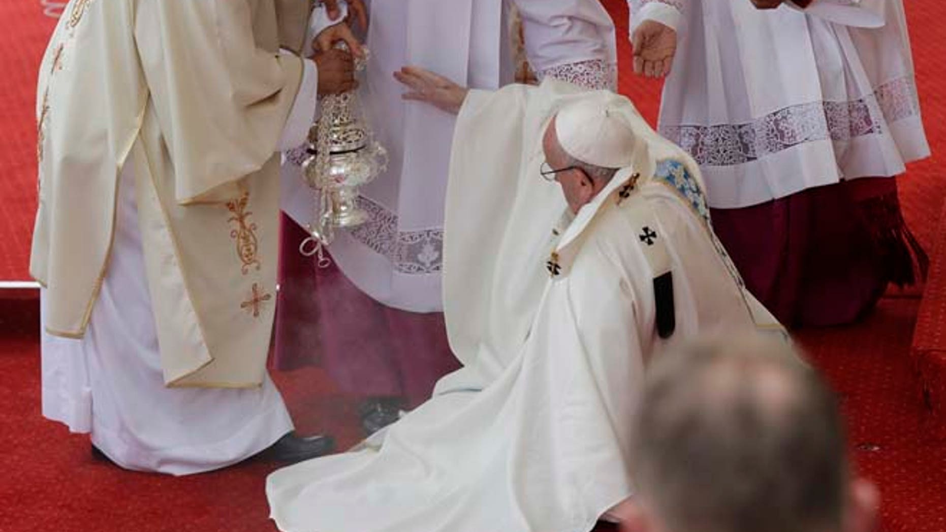 Pope Francis is helped by Vatican Master of Ceremonies, Mons. Guido Marini as he stumbles on the altar as he celebrates a mass in Czestochowa, Poland