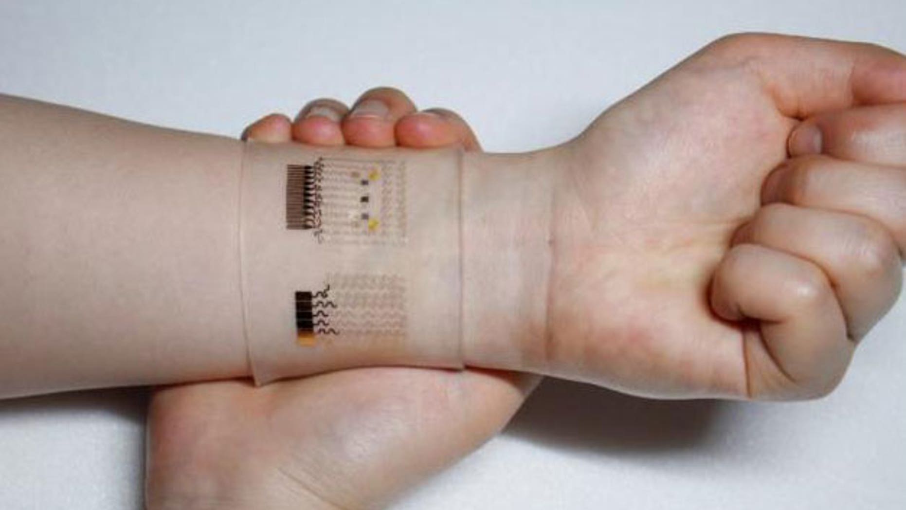 An optical image of the GP-hybrid electrochemical device array on the human skin.