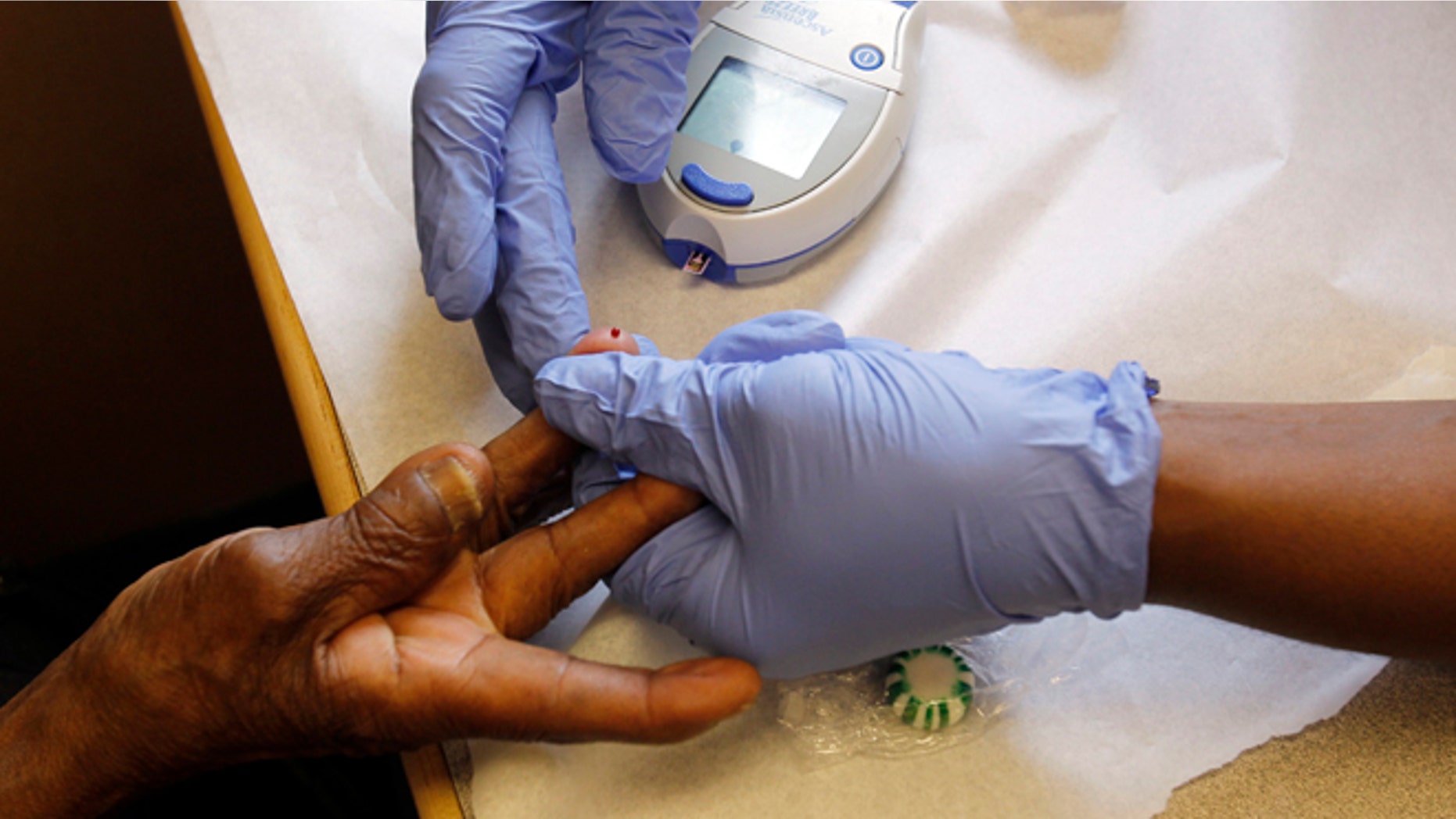 Client Viola Sanon has her finger pricked for a blood sugar test in the Family Van in Boston, Massachusetts, August 9, 2010. Every week, dozens of residents of this low-income Boston neighborhood stop into the Family Van, an RV manned by healthcare workers affiliated with Harvard Medical School who perform simple, free screenings, including blood pressure, body mass index and blood sugar, which can alert patients if they face an elevated risk for diabetes, hypertension or other chronic conditions. REUTERS/Brian Snyder (UNITED STATES - Tags: HEALTH SOCIETY)