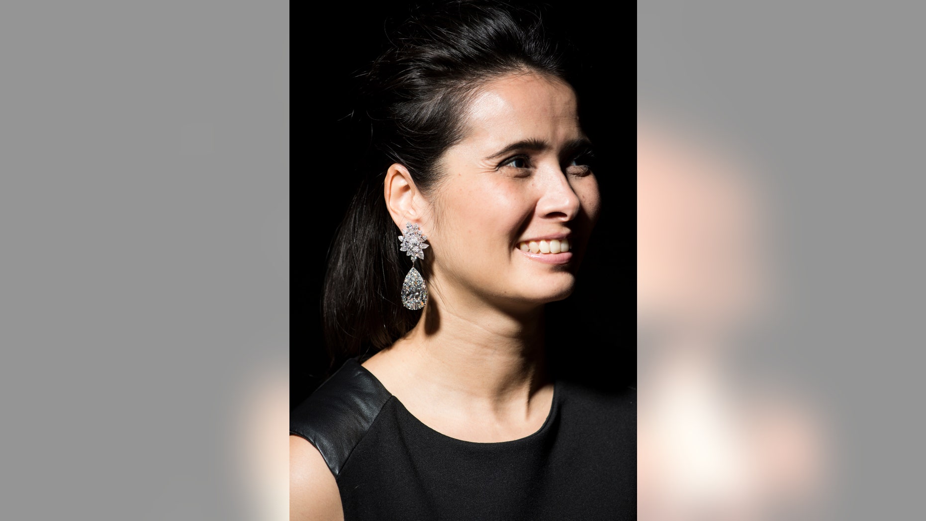 A model displays a pair of stunning diamond earrings "Miroir de l'Amour" weighing 52.55 and 50.47 carats during a Christie's press preview in Geneva, Switzerland, Thursday, Nov. 10, 2016.