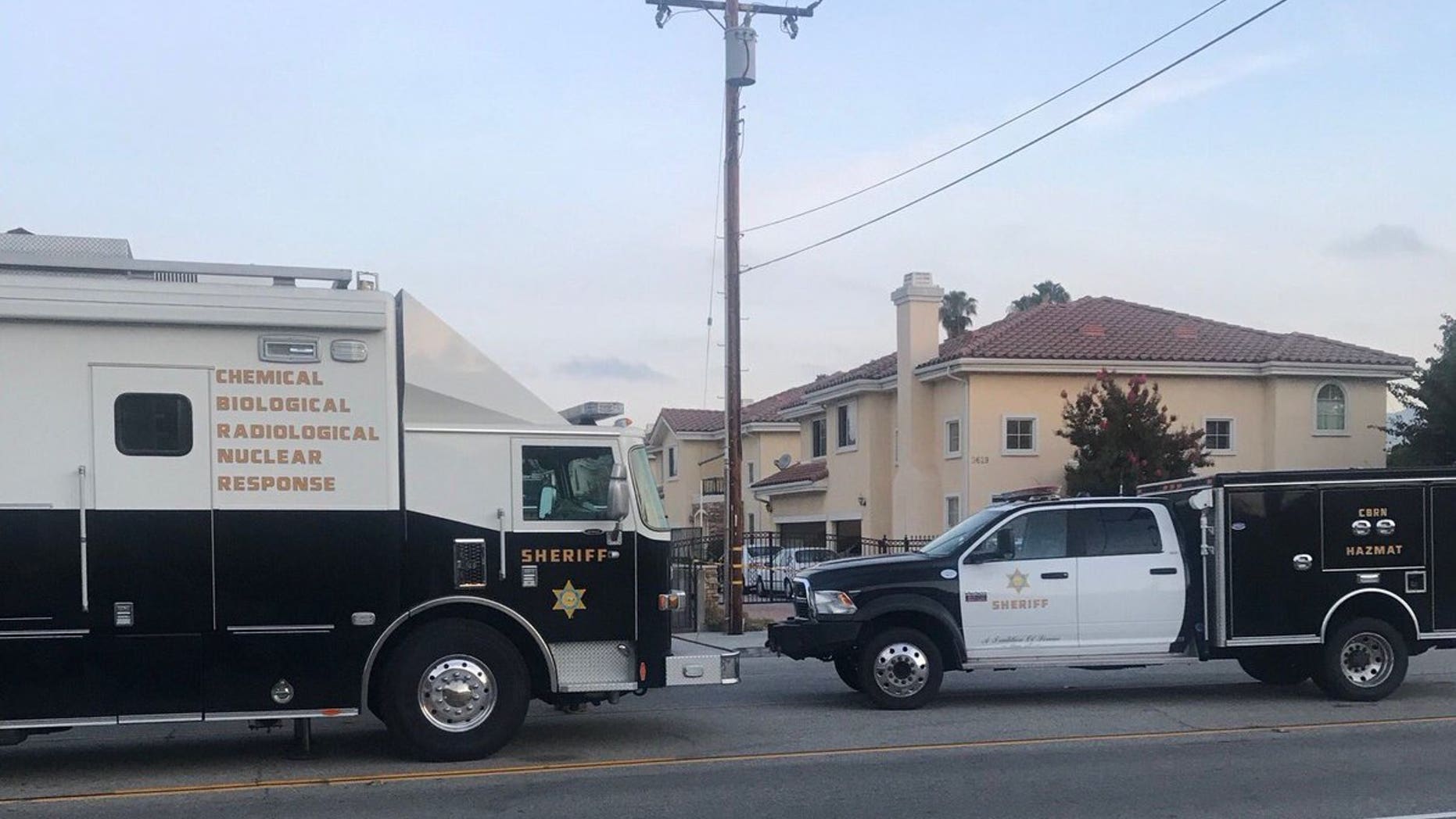 El Monte police vehicles are seen near the site where an unknown suspect doused a woman with a "caustic chemical."