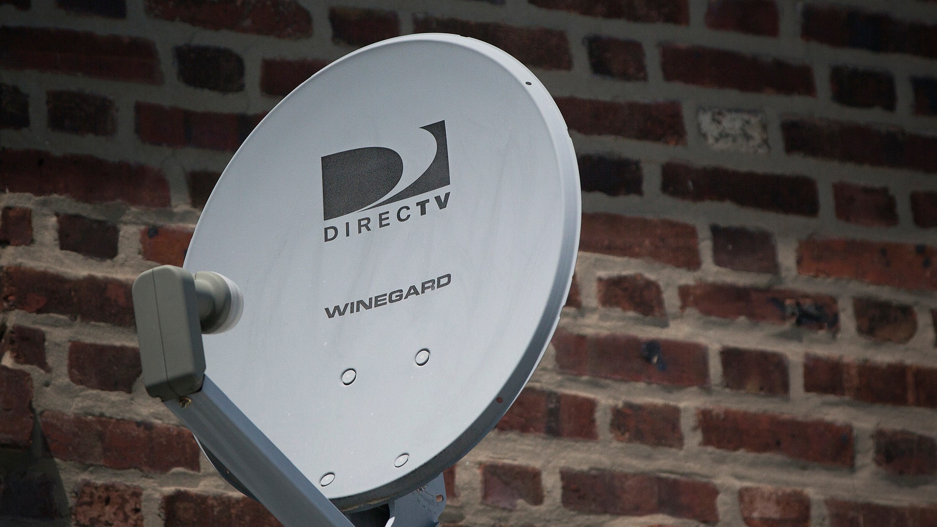 A Direct TV dish is seen outside a home in the Queens borough of New York July 29, 2013. Satellite TV provider DirecTV reported August 1, 2013 that it missed second-quarter earnings estimates as it lost more customers than expected in the United States and added fewer than expected in its Latin American unit. REUTERS/Shannon Stapleton (UNITED STATES - Tags: BUSINESS) - RTX126Z1