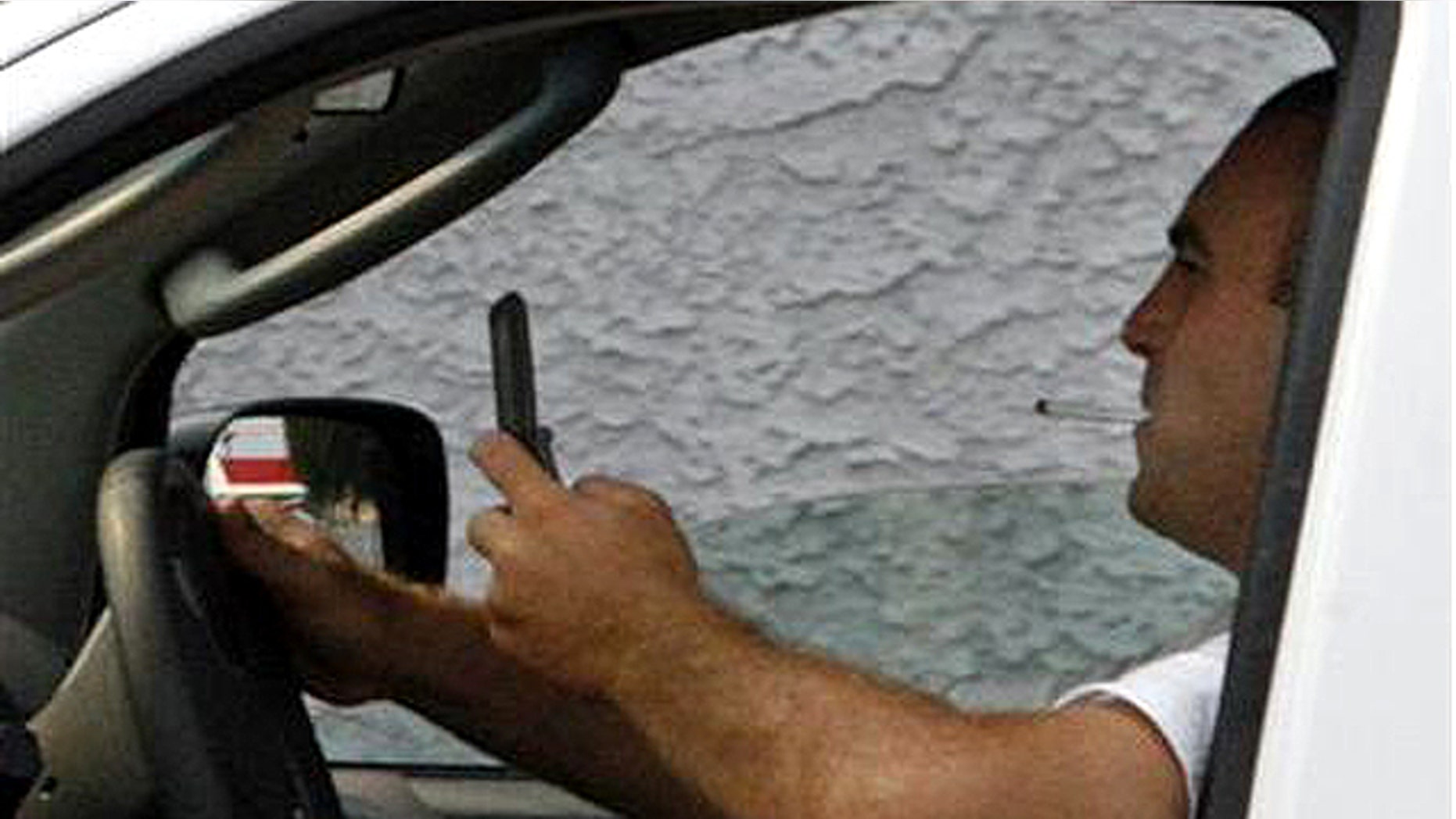 A man uses a cell phone while driving in Burbank, California June 25, 2008.