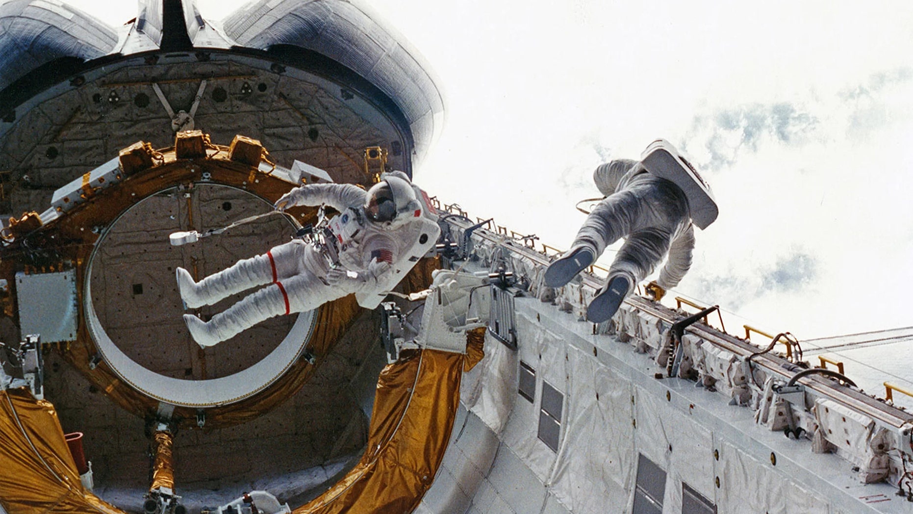 STS-6 crewmates Don Peterson (at right) and Story Musgrave perform the first shuttle-era spacewalk outside Challenger in 1983. (Credit: NASA)