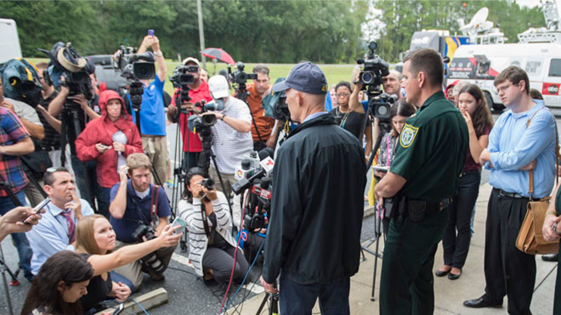 Sept. 19, 2014: Florida Gov. Rick Scott, left, and Gilcrist county sheriff Robert Schultz, right, talk to the media