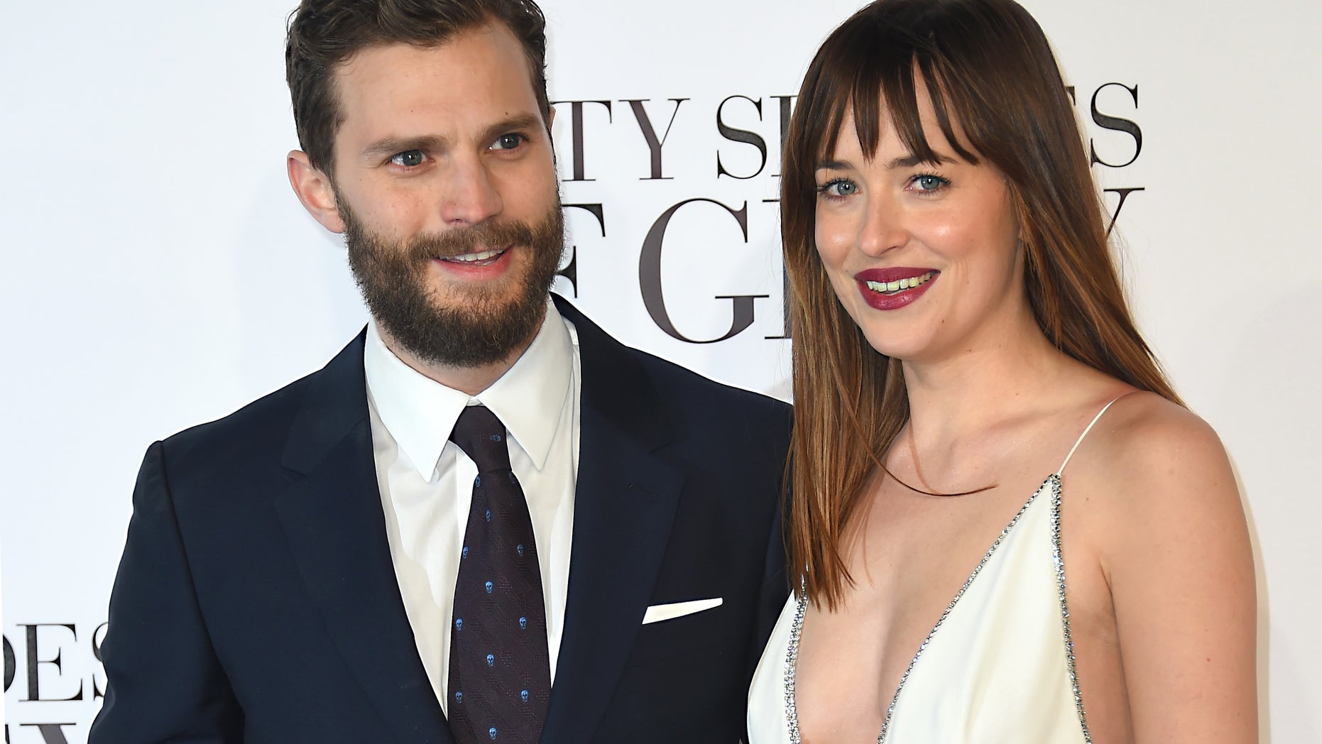 Feb 12, 2015. Dakota Johnson, right, and Jamie Dornan pose for photographers at the UK Premiere of "Fifty Shades of Grey" in London.
