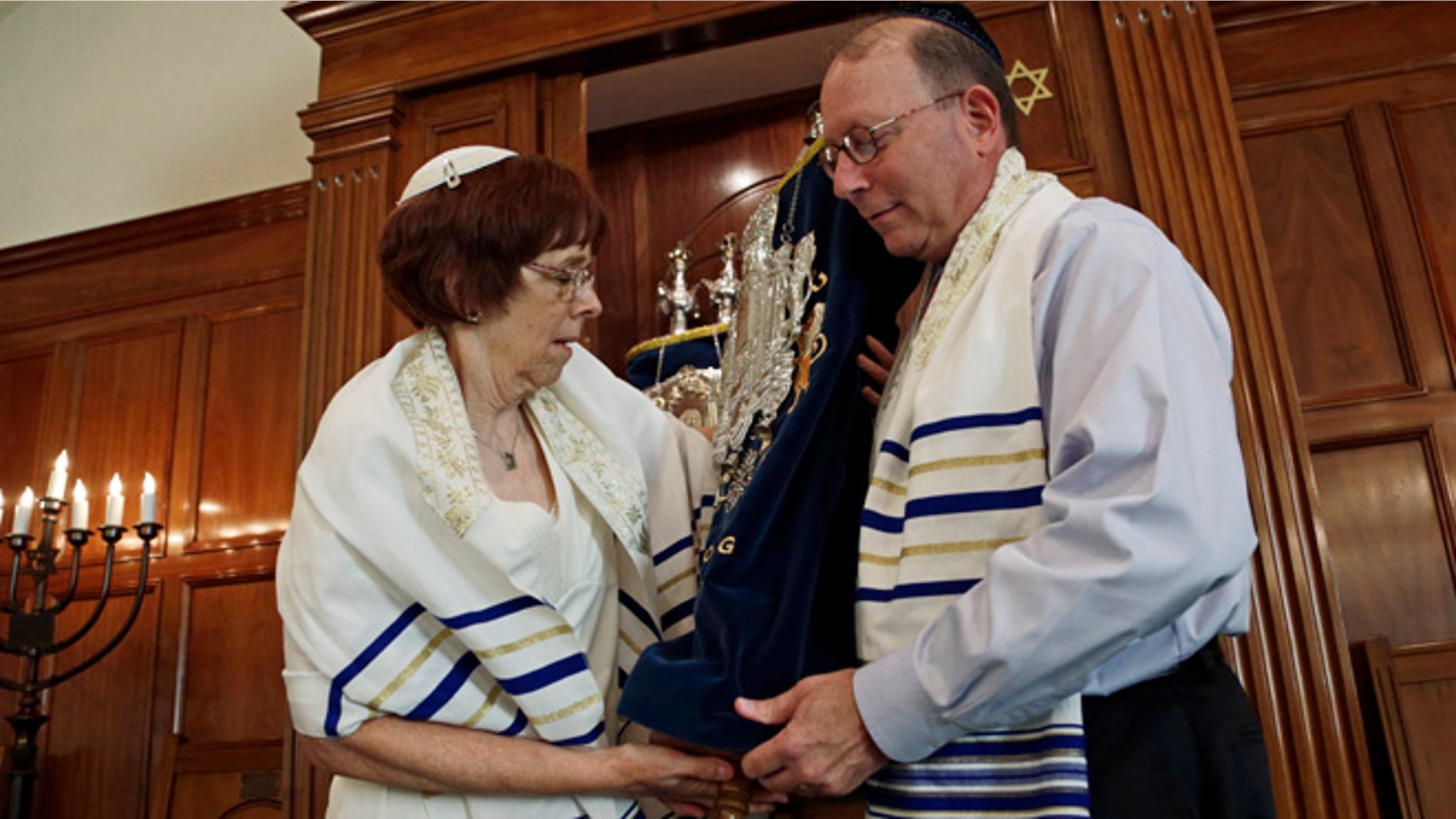 Oct. 2, 2013: In this photo, Rabbi Lynne Goldsmith and her husband Rob Goldsmith remove the Torah from the Ark inside Temple Emanu-El in Dothan, Ala. Faced with a dwindling, aging congregation, members of a south Alabama synagogue five years ago began recruiting Jews to move to Dothan with the promise of $50,000 in relocation assistance.