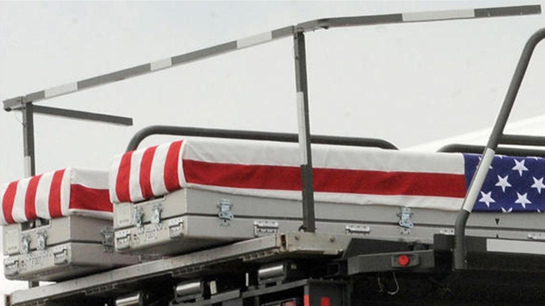 Transfer cases containing the remains of Pfc. Joshua L. Jetton, left case, and Sgt. James W. Harvey II, right case, sit on a loader during a prayer Wednesday, June 22, 2011 at Dover Air Force Base, Del. According to the Department of Defense, Jetton, of Sebring, Fla., died while supporting Operation Enduring Freedom and Harvey, 23, of Toms River, N.J., died June 20 in Ghazni province, Afghanistan of wounds sustained when insurgents attacked his unit with small arms fire. (AP Photo/Steve Ruark)