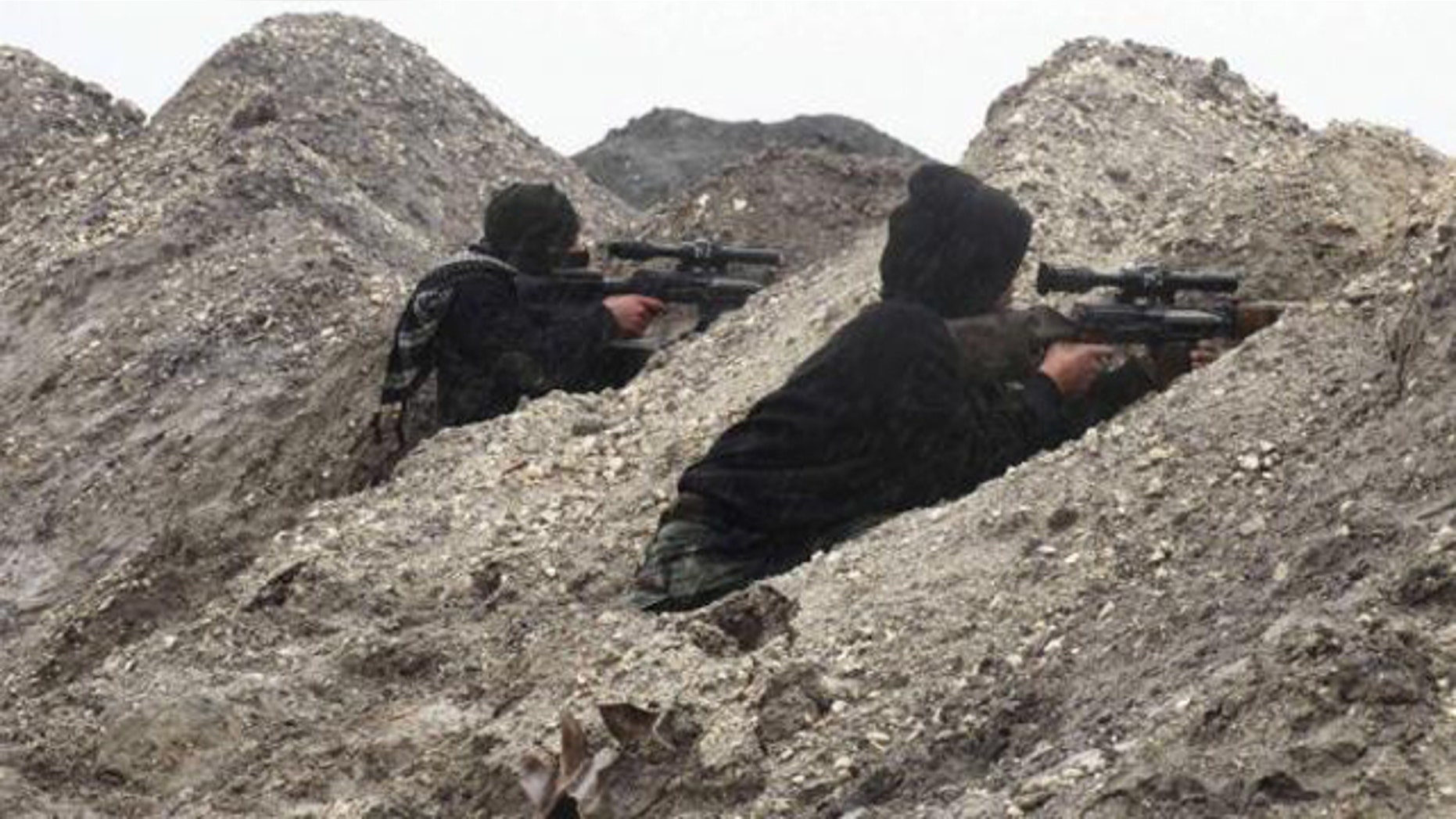 Jan. 5, 2015: Rebel fighters take positions behind sand barricades at al-Breij frontline, after what they said was an advance by them in al-Manasher and al-Majbal areas, where forces loyal to Syria's President Bashar al-Assad were stationed, in Aleppo. (REUTERS/ABDALGHNE KAROOF)
