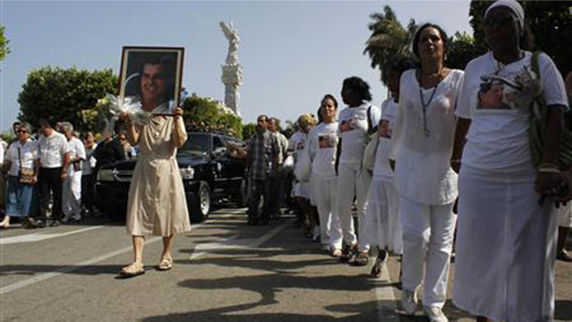 July 24, 2012: Members of the 'Ladies in White' opposition group march beside the funeral procession of Oswaldo Paya, one of Cuba's best-known dissidents, in Havana. (Reuters/File)