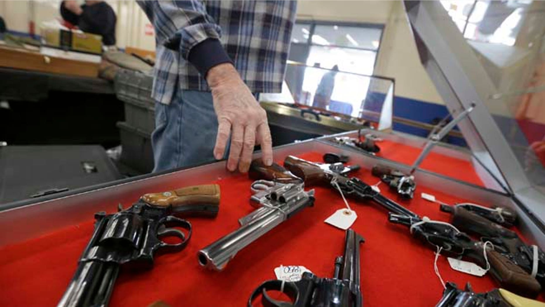 Feb. 6, 2015: Gun salesman arranges handguns in a display case in advance of a show at the Arkansas State Fairgrounds in Little Rock, Ark.