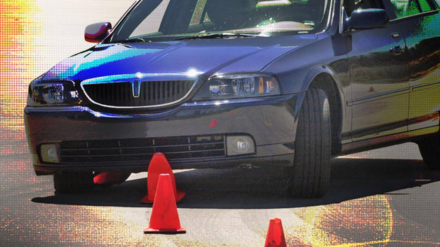 ** FILE **A test vehicle with its electronic stability control turned off slides over cones during a test in Auburn Hills, Mich., in this July 16, 2003 file photo. The government, impressed by the promise of anti-rollover technology, is planning to require automakers to include electronic stability control devices on all new vehicles in the coming years. The National Highway Traffic Safety Administration is set to unveil proposed rules for stability control on Thursday, Sept. 14, 2006 that also will include testing standards for auto manufacturers. (AP Photo/Carlos Osorio)
