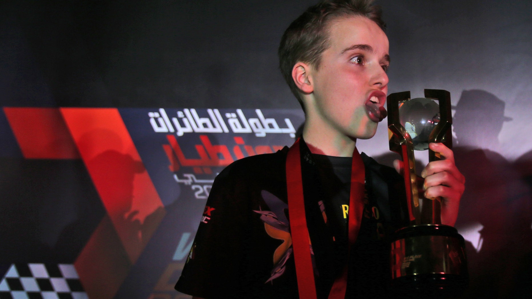 Luke Bannister of Somerset, a 15 year old British pilot of Bannisters team, Tornado X-Blades Banni UK, holds the trophy after he won the first World Drone Prix in Dubai, United Arab Emirates, Saturday, March 12, 2016. (AP Photo/Kamran Jebreili)
