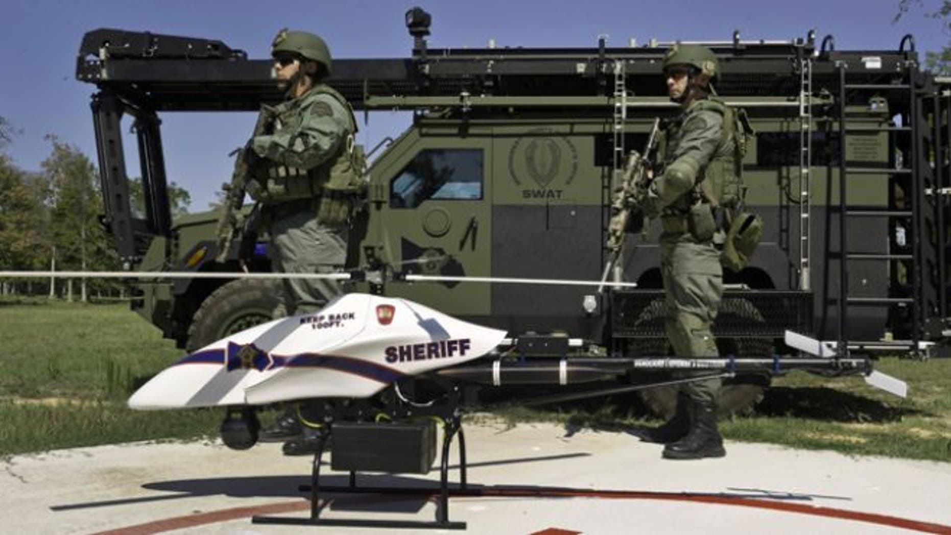 Sept. 2011: This photo provided by Vanguard Defense Industries, shows a ShadowHawk drone with Montgomery County, Texas, SWAT team members.
