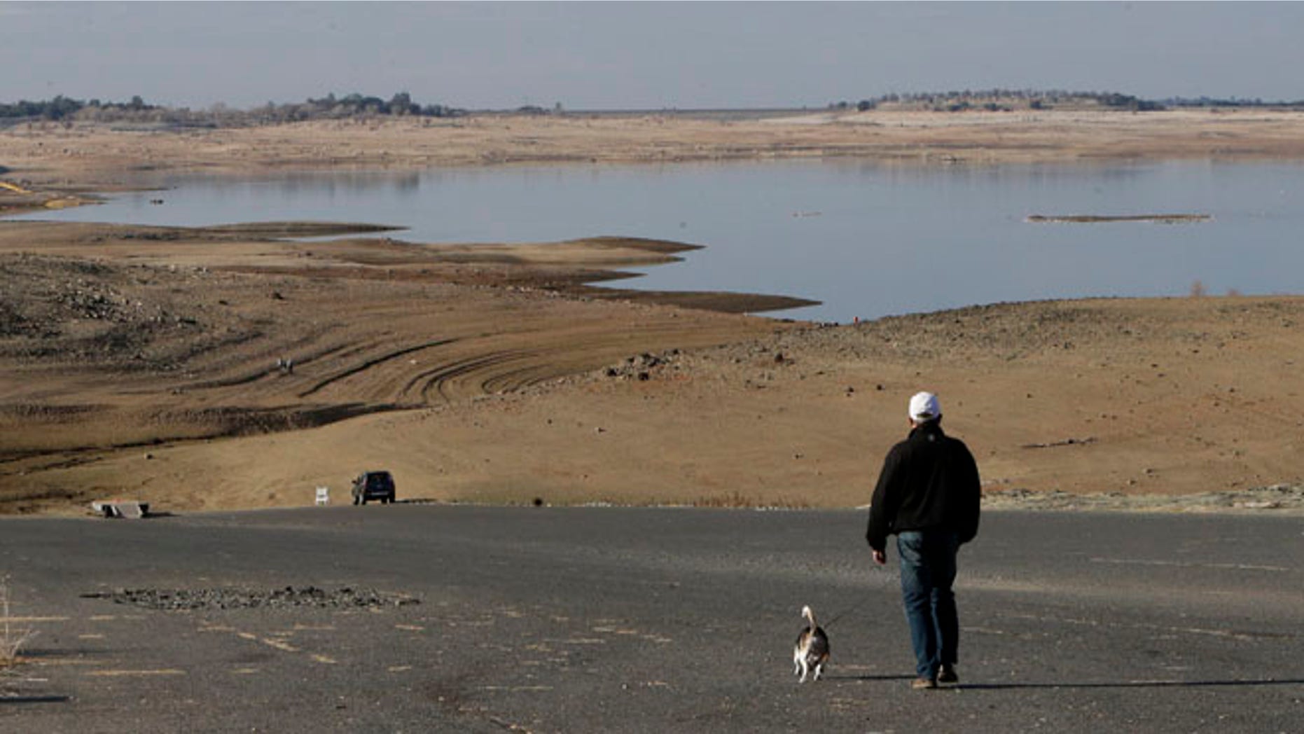 Jan. 9, 2014: In this file photo a visitor to Folsom Lake, Calif., walks his dog down a boat ramp that is now several hundred yards away from the waters edge, in Folsom, Calif.