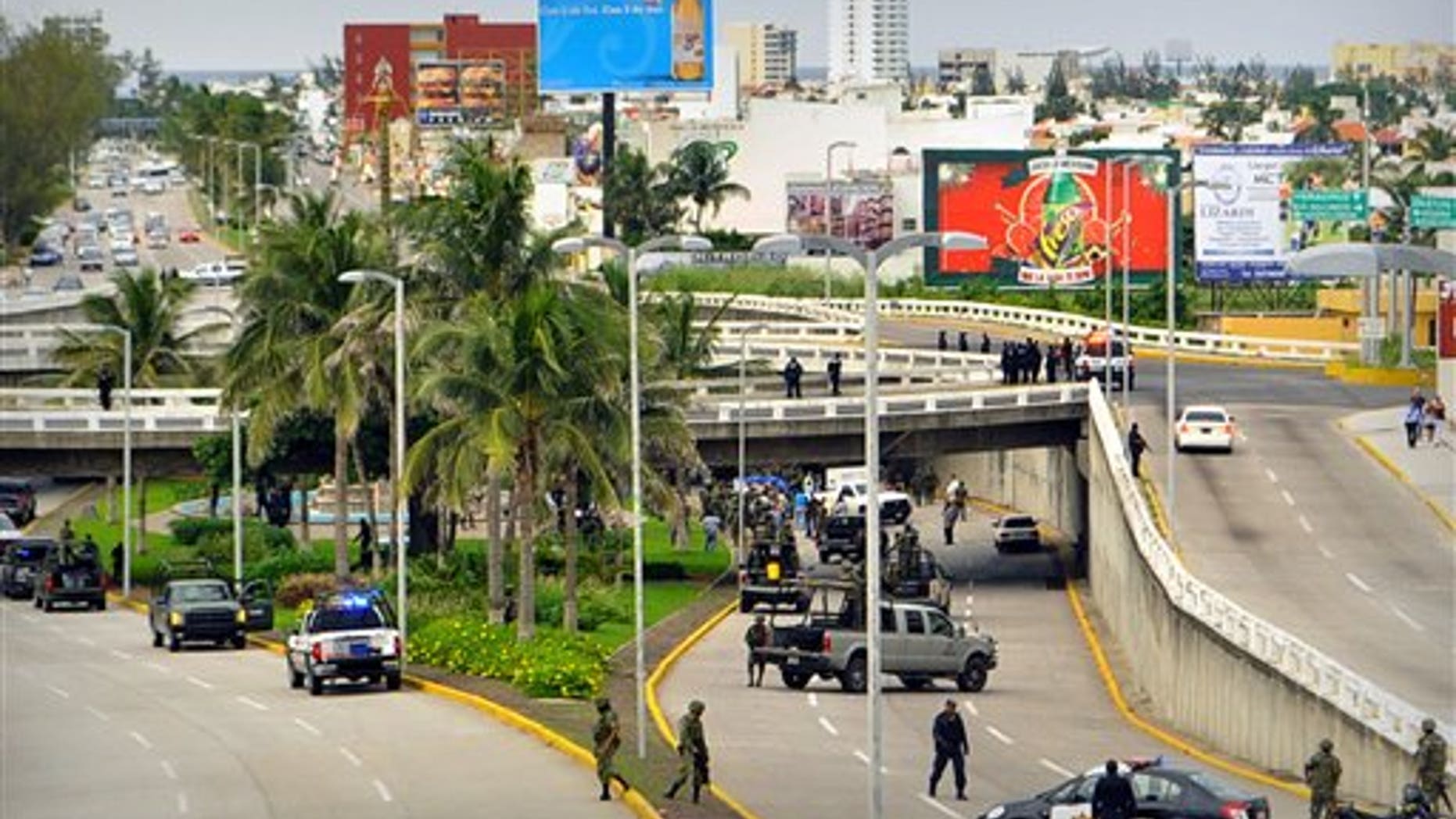 Sept 20: Soldiers and police block off an area where 35 bodies lie under an overpass in Veracruz, Mexico. Masked gunmen blocked traffic and left the bodies piled in two trucks and on the ground, according to authorities. The nation is now dominated by two powerful organizations that appear poised for a one-on-one battle to control drug markets and trafficking routes. (AP Photo)