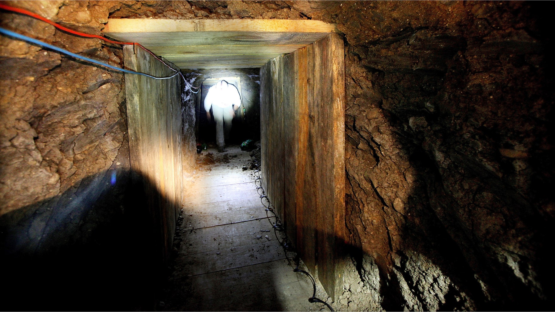 An investigater combs through a drug tunnel found in a wherehouse on November 30, 2011 in Otay Mesa, California.