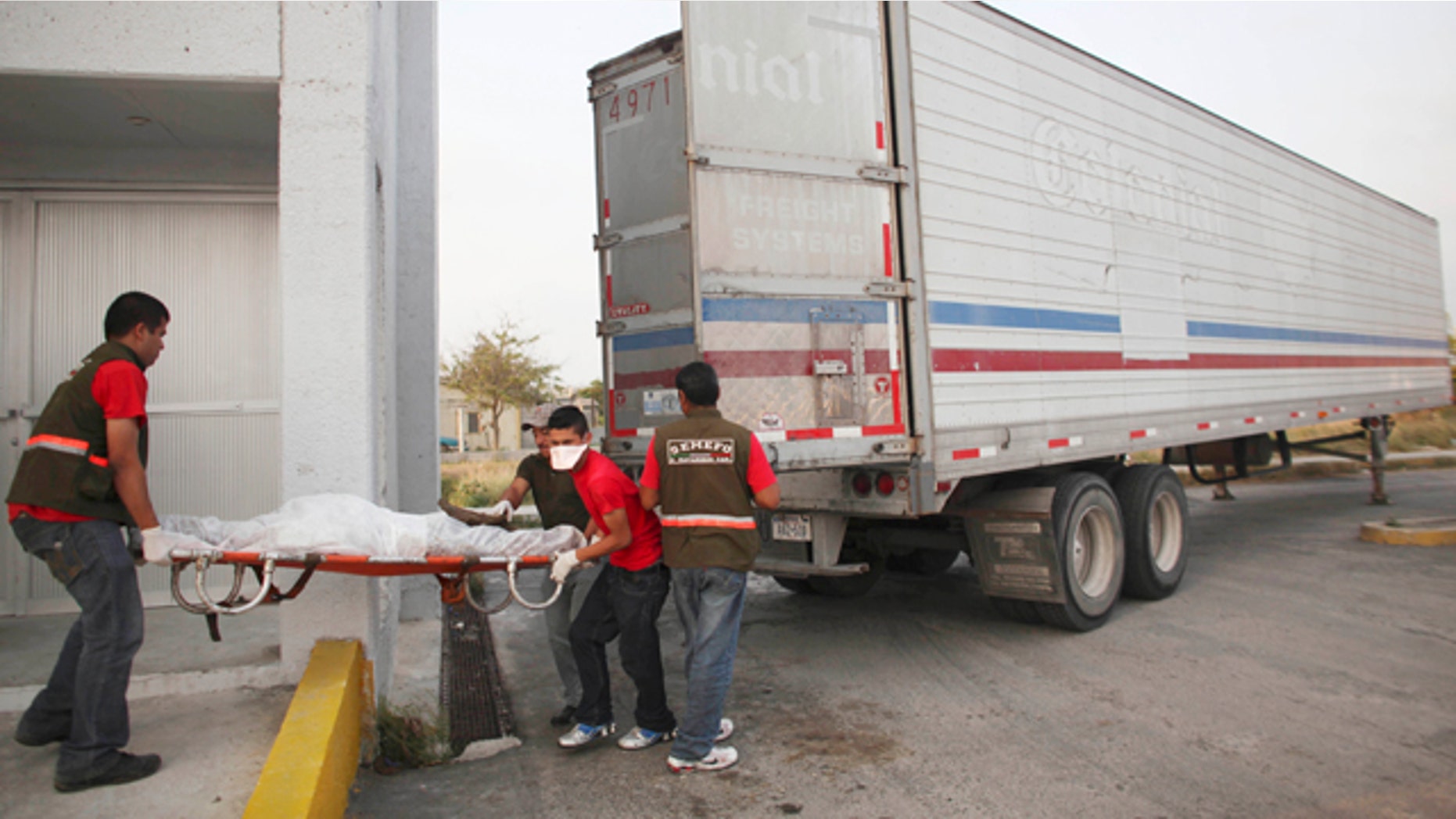 April 7 2011: Morgue workers remove a body found in a mass grave from a refrigerated truck in Matamoros, northern Mexico.