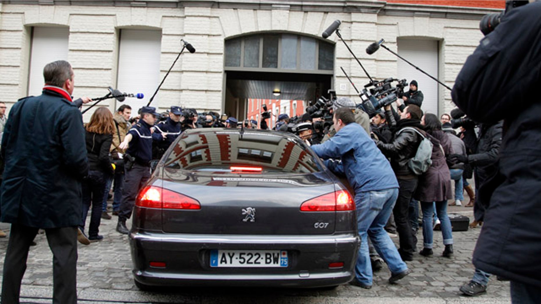 Feb. 21: The car of Dominique Strauss-Kahn enters the Gendarmerie surrounded by the media as he arrives for questioning.